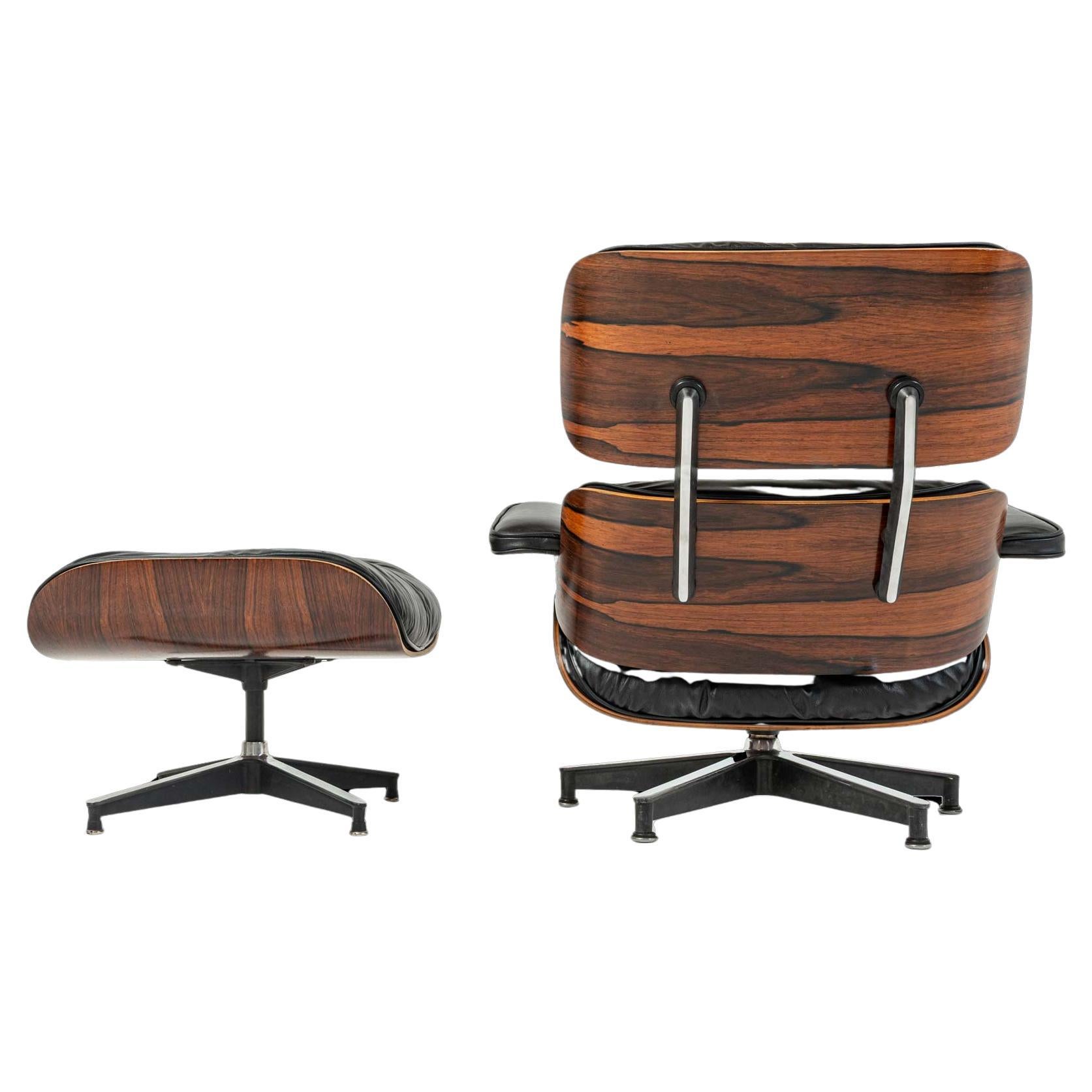 Este coleccionable extremadamente raro es una de las primeras producciones conocidas del sillón Eames de 1956 con otomana, sin estructura estampada. En la clásica carcasa lacada en negro y palisandro, esta pieza ha sido restaurada profesionalmente e