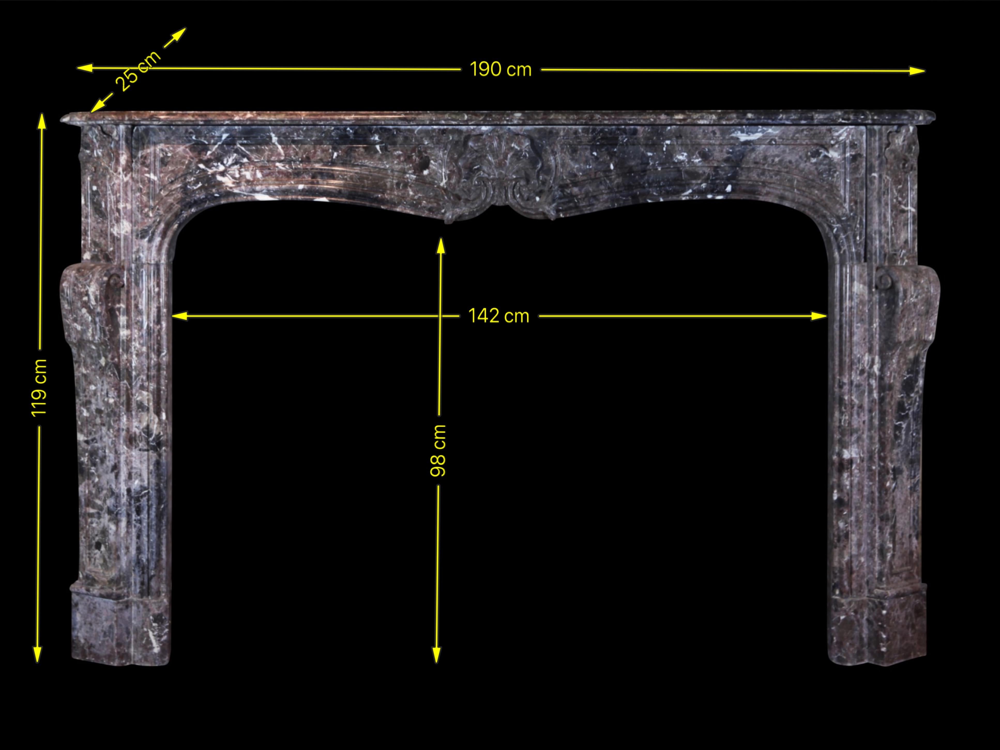 Excepcional chimenea antigua original de la época de la regencia francesa, 1ª mitad del siglo XVIII. Esta pieza se instaló en un gran salón con una pared de panel de roble. El mármol oscuro real y el tallado profundo son signo de una decoración