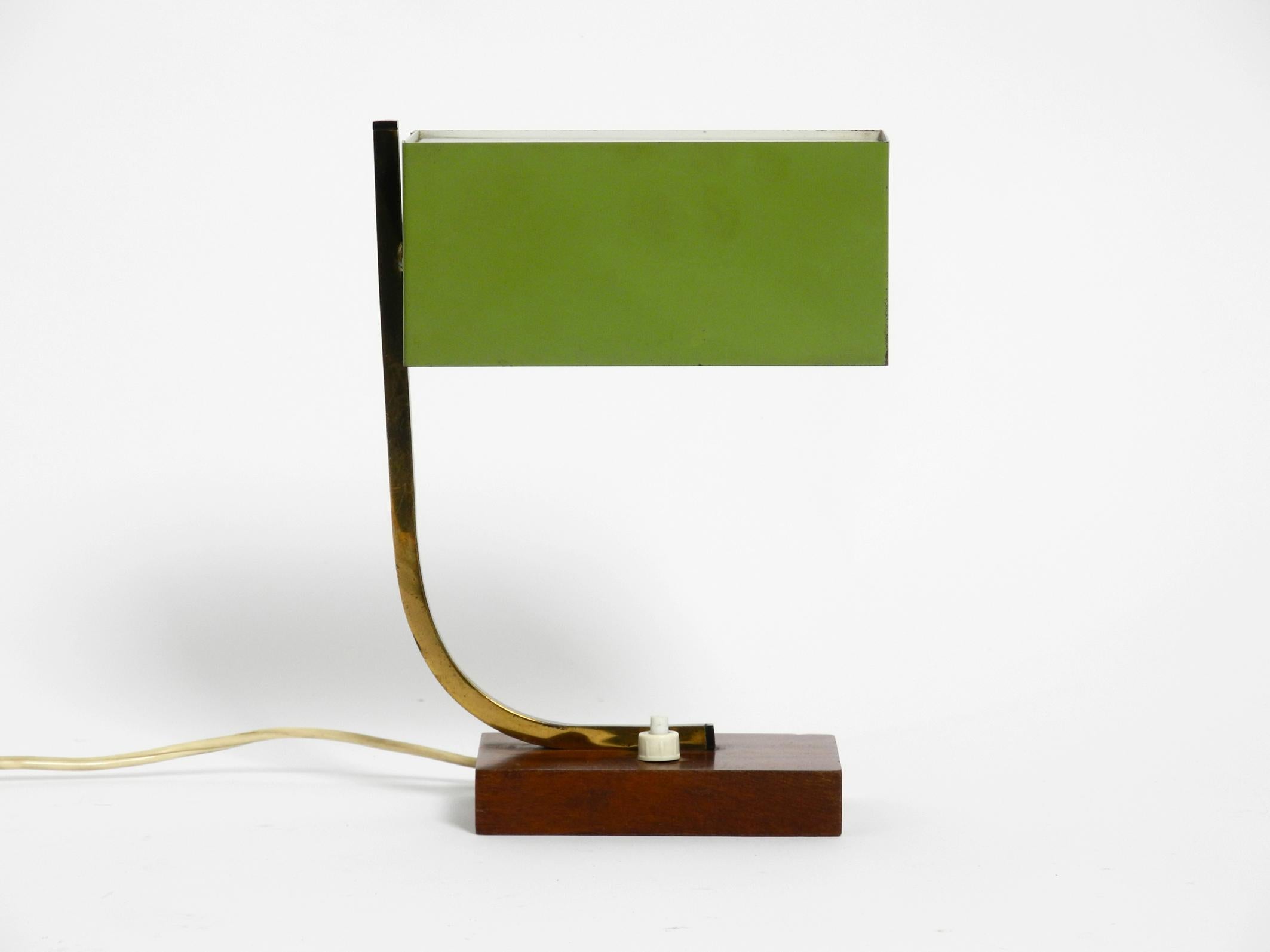 Stunning green Mid-Century Modern metal bedside lamp with wooden base.
Great minimalistic 1950s design. Made in Italy.
Very rare with a rectangular shade.
The shade can be rotated steplessly.
Very high quality made of metal. Brass neck. Walnut