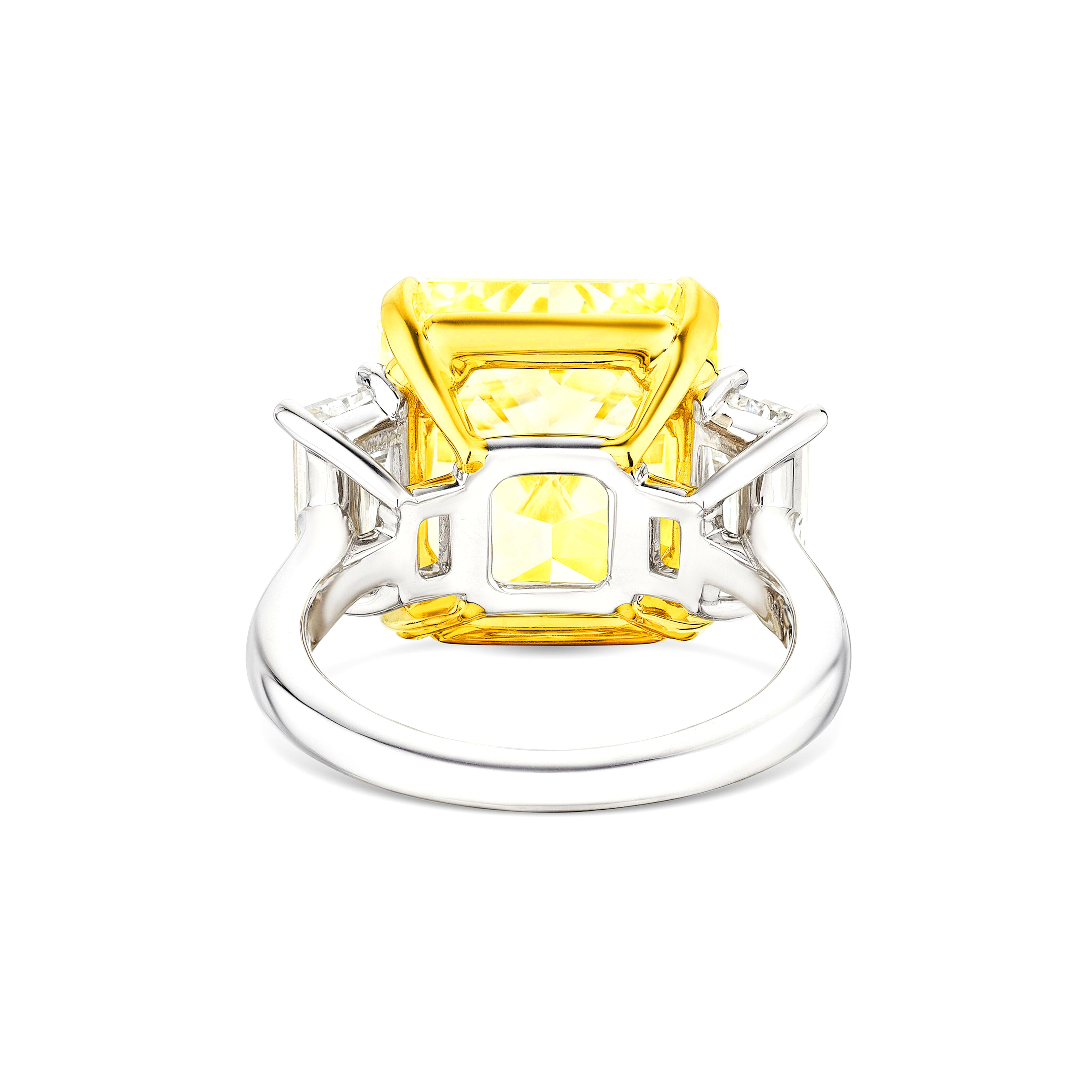 Cette pièce exceptionnelle comporte un superbe diamant central de couleur jaune fantaisie qui présente une clarté VVS1 et une brillance remarquables, complété par deux exquis diamants latéraux trapézoïdaux, tous deux de couleur E et de clarté VVS.