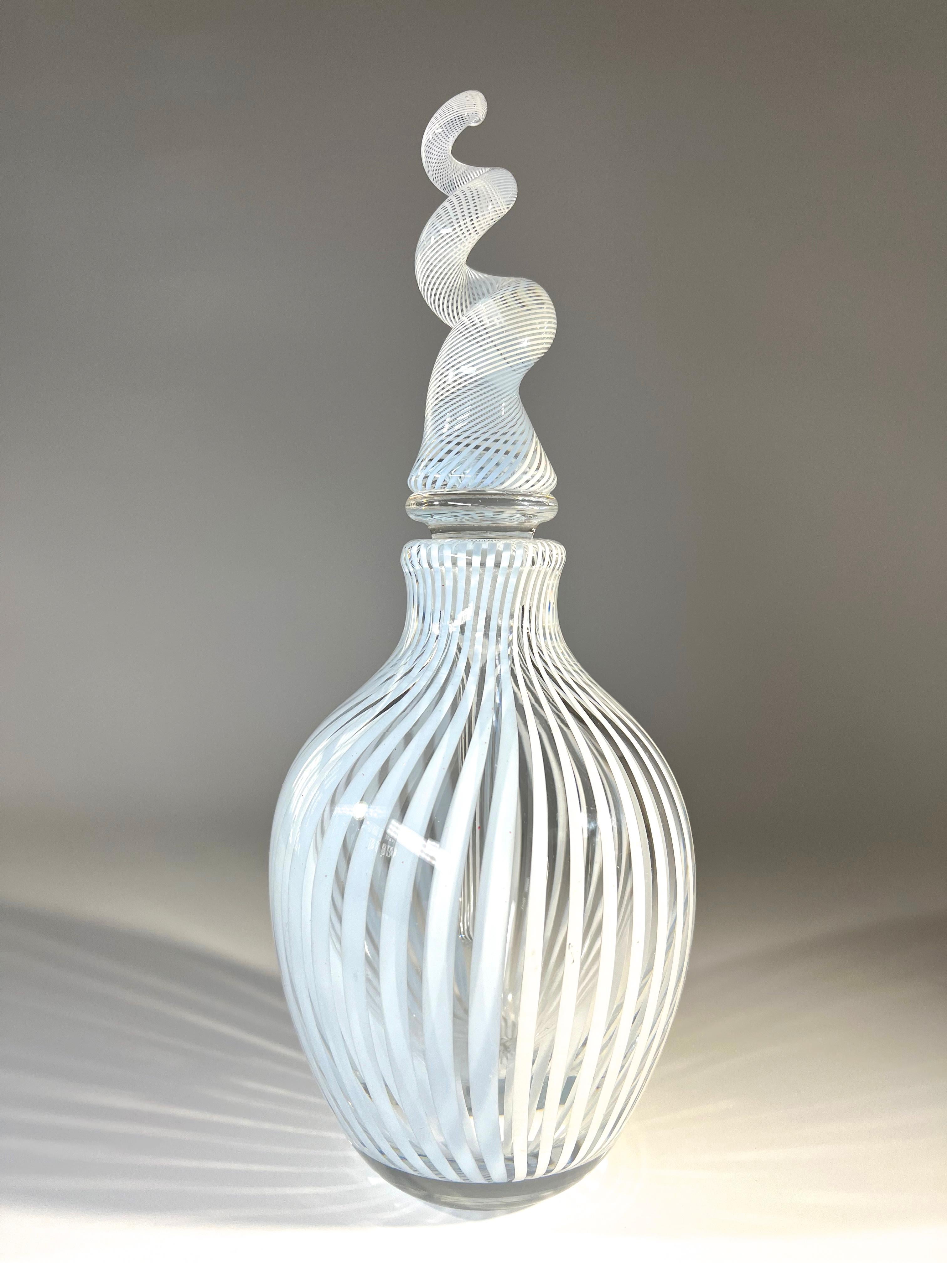 Harlequin white and the palest of blue stripes, decorate both this bottle and it's extraordinary spiral stopper
This is an exceptional piece from the renowned glass artist, Mike Hunter of Twists Studio in Scotland
Signature etched to base, has