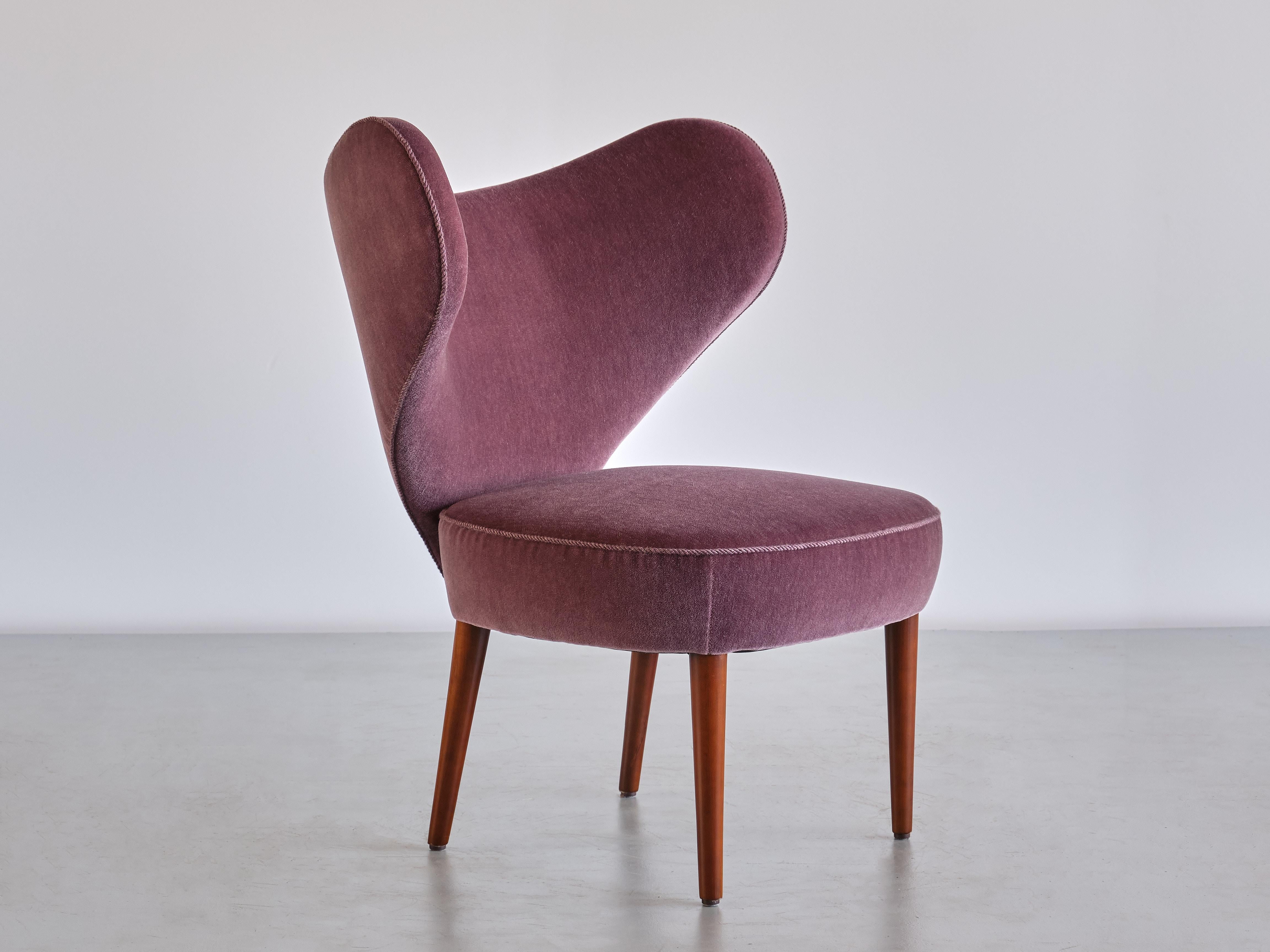 This exceptionally rare chair was produced by the Danish company Brøndbyøster Møbel & Trævarefabrik A/S in 1953. The model was aptly named 'Hjertestolen' which is Danish for 'Heart Chair'. 
The exuberant design is marked by the heart shaped back and