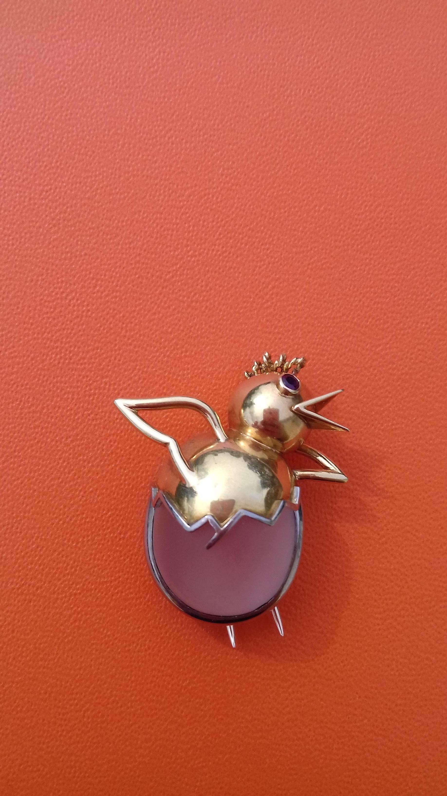 Adorable Authentic Hermès Brooch

In shape of a Chick coming out of its eggshell

Made in France in the 60's

Made of yellow and grey gold

The eggshell is formed of a frosted glass paste cabochon surrounded by a grey gold thread

The chick is made