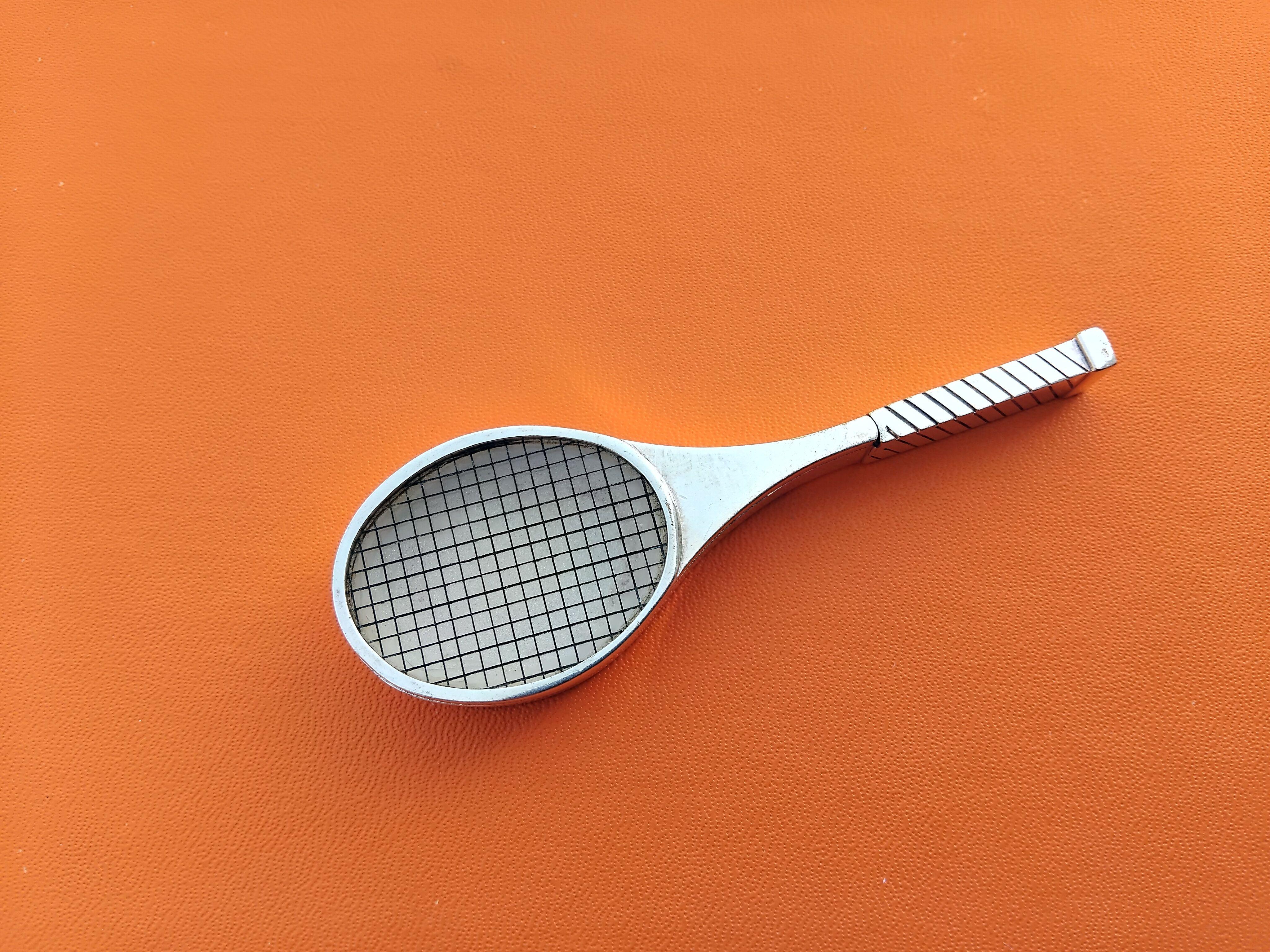 Rare and Collectible Authentic Hermès Pill Box

Tennis Racquet Shaped

Vintage item

Made of metal, answers to the silver test

The lid is made of transparent plastic on which are drawn lines representing the ropes of the racquet

Opens by sliding