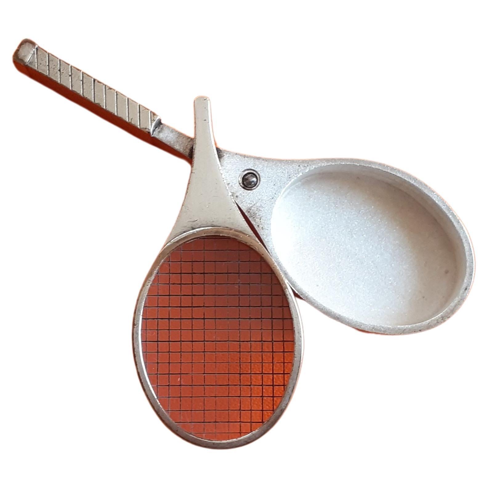 Rare and Collectible Authentic Hermès Pill Box

Tennis Racquet Shaped

Vintage item

Made of metal

The lid is made of transparent plastic on which are drawn lines representing the ropes of the racquet

Opens by sliding the lid 

