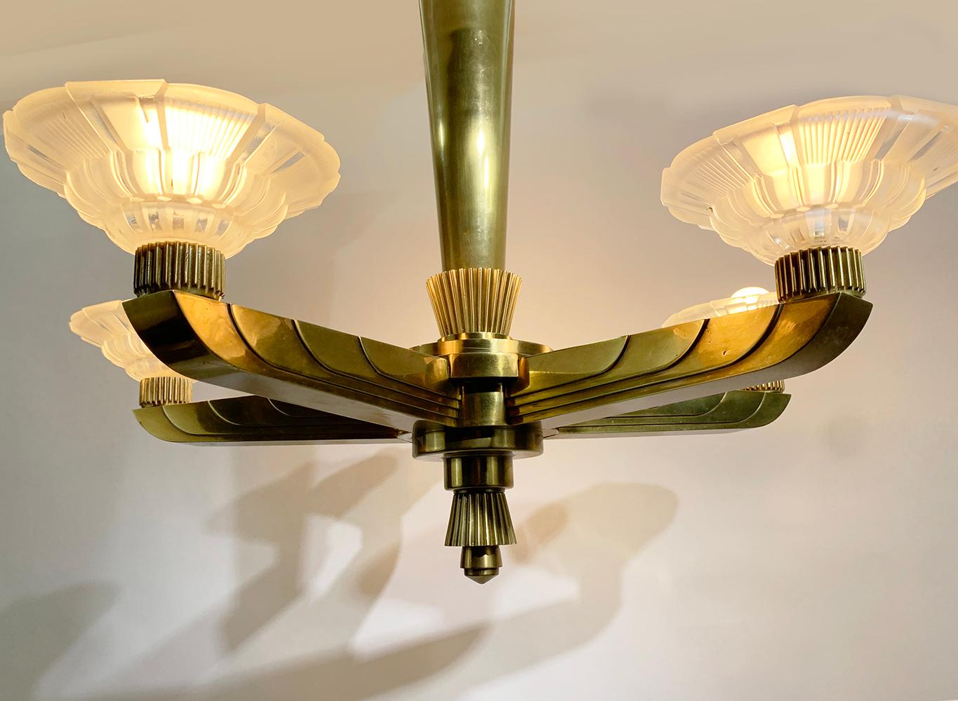 A stunning French art deco chandelier by Hettier et Vincent, circa 1930.
The fixture holds five uplight rare cups in moulded-pressed glass signed Hettier & Vincent, France with its art deco geometric shape bronze structure.
 