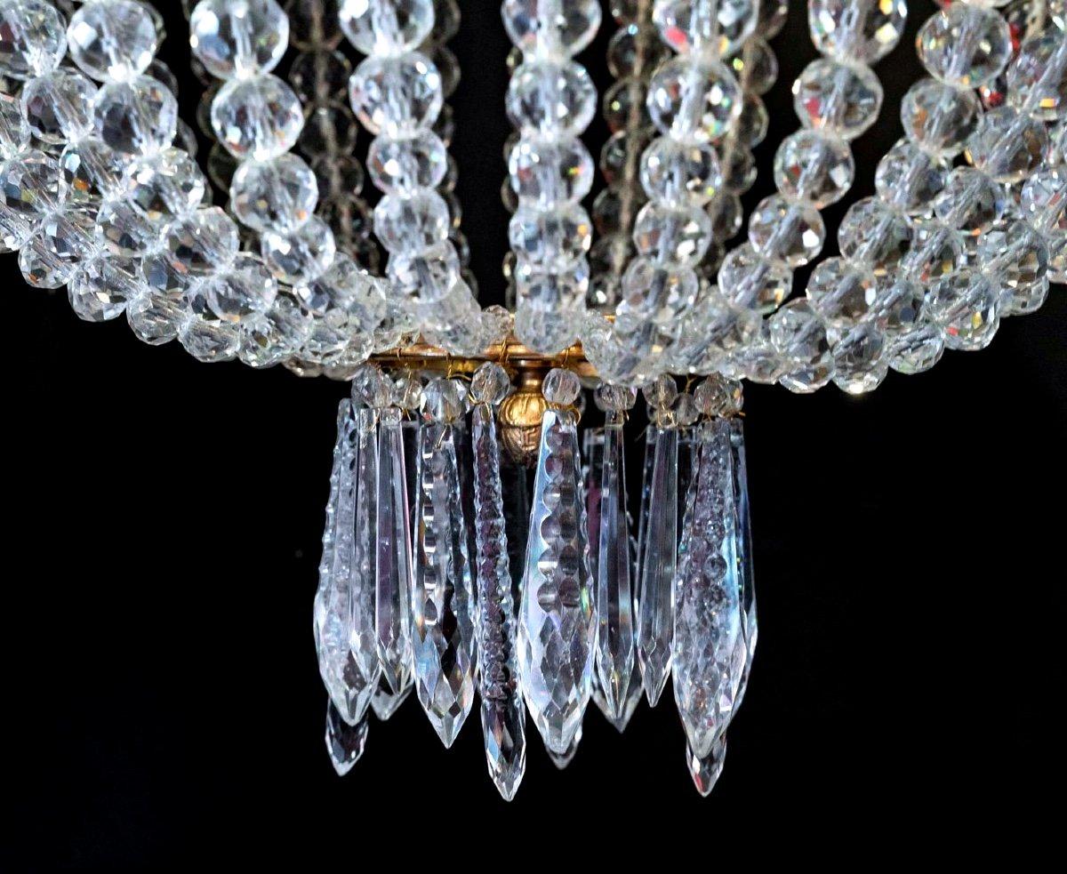 Exceptional chandelier called “Montgolfière”.
Fully electrified, its frame is in gilded bronze composed of a central part supporting 6 gilt bronze sconces where the sockets support lovely little screw bulbs.

Its crystal collar cut in the shape