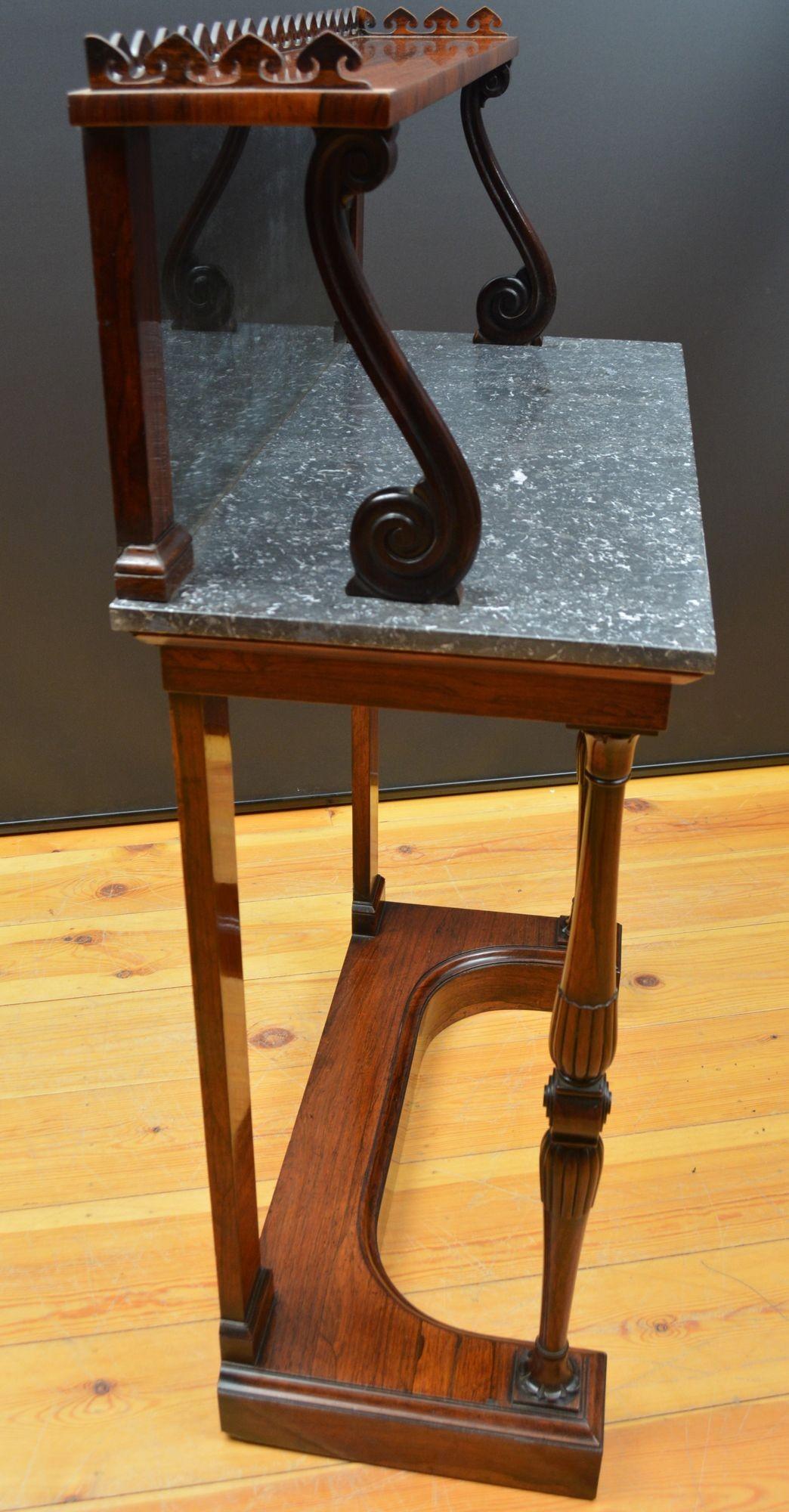 ST061 Exceptional Irish quality regency rosewood console table of slim proportions, with a inverted heart shaped gallery to the top shelf,
supported on S scroll supports. This console table retains its original mirror plate that is profusely foxed