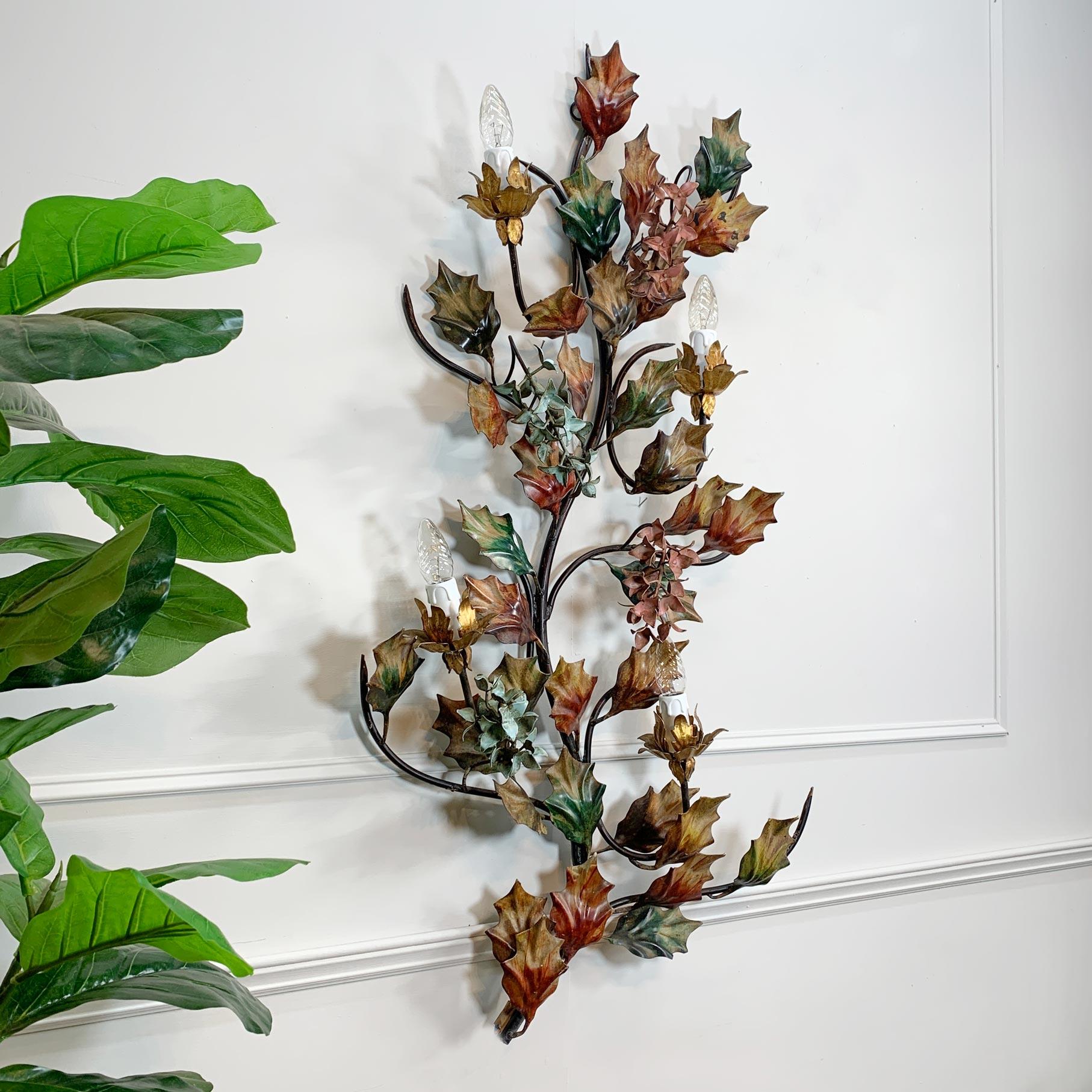 Stunningly detailed wall light, hand crafted holly leaves interspersed with wisteria flowers, the entire piece has been painstakingly hand-painted, in vivid natural greens, autumnal tan, browns and reddish hues. The wisteria flowers in soft duck egg