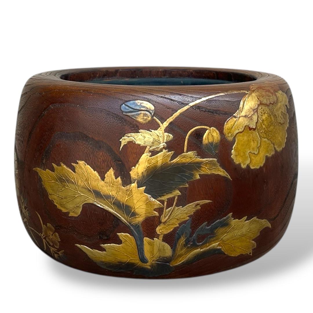 This magnificent hibachi (charcoal brazier), likely custom-made to order, exemplifies the pinnacle of Japanese lacquer artistry of the 19th century. Carved from solid wood with a rich natural grain, the surface is adorned with an exquisite maki-e