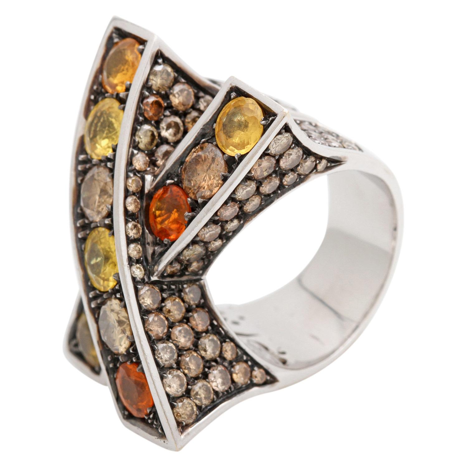 Exceptional ladies' ring with 4 brown brilliant-cut diamonds totaling approx. 1.38 ct, 7 yellow sapphires totaling approx. 4.39 ct and brown brilliant-cut diamonds on the side totaling approx. 8.37 ct. WG 18K, partially blackened, crossed ring head.