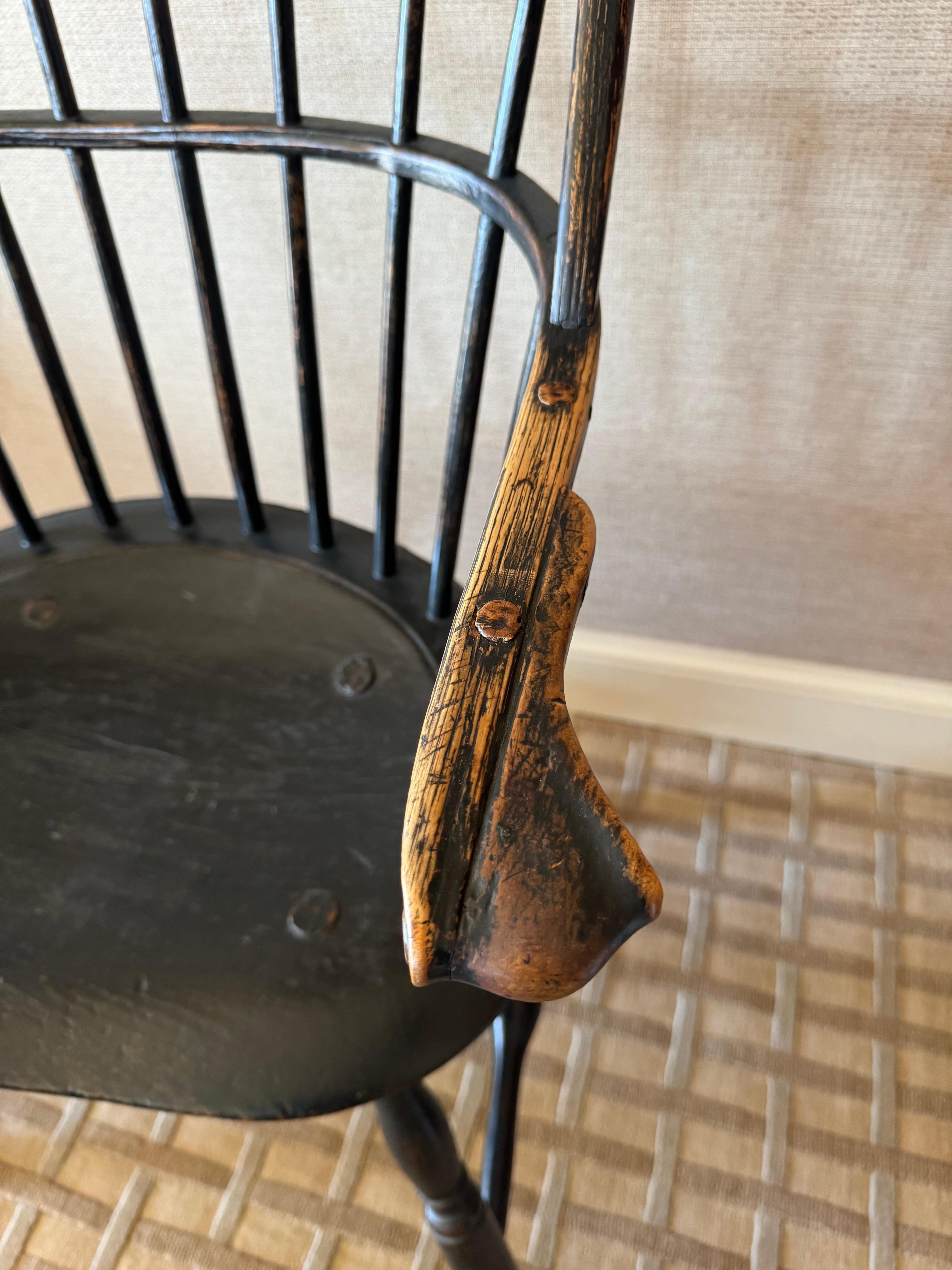 This is an exceptionally fine Lancaster, Pennsylvania  Sack Back Windsor Armchair, circa 1780. It has a bowed crest rail mortised into a continuous rear rail with eleven spindles, seven of which are full height. The continuous rail terminates in