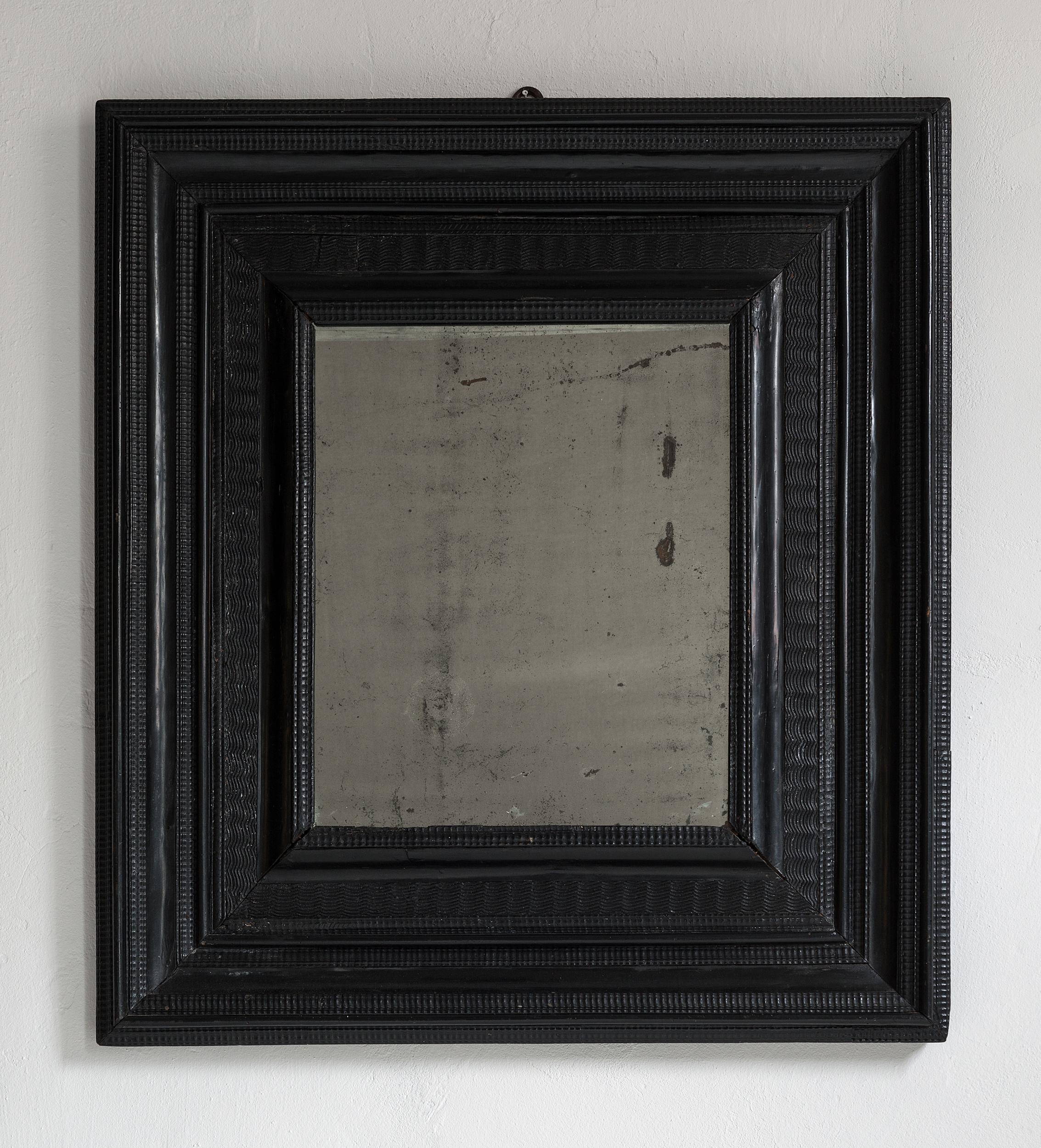 An original 17th century ripple molded combination profile cabinet mirror, Flanders, circa 1650.

The mirror plate very old and spotty possibly original to the piece. Old, original iron hook, hand forged.

An important piece of great patina,