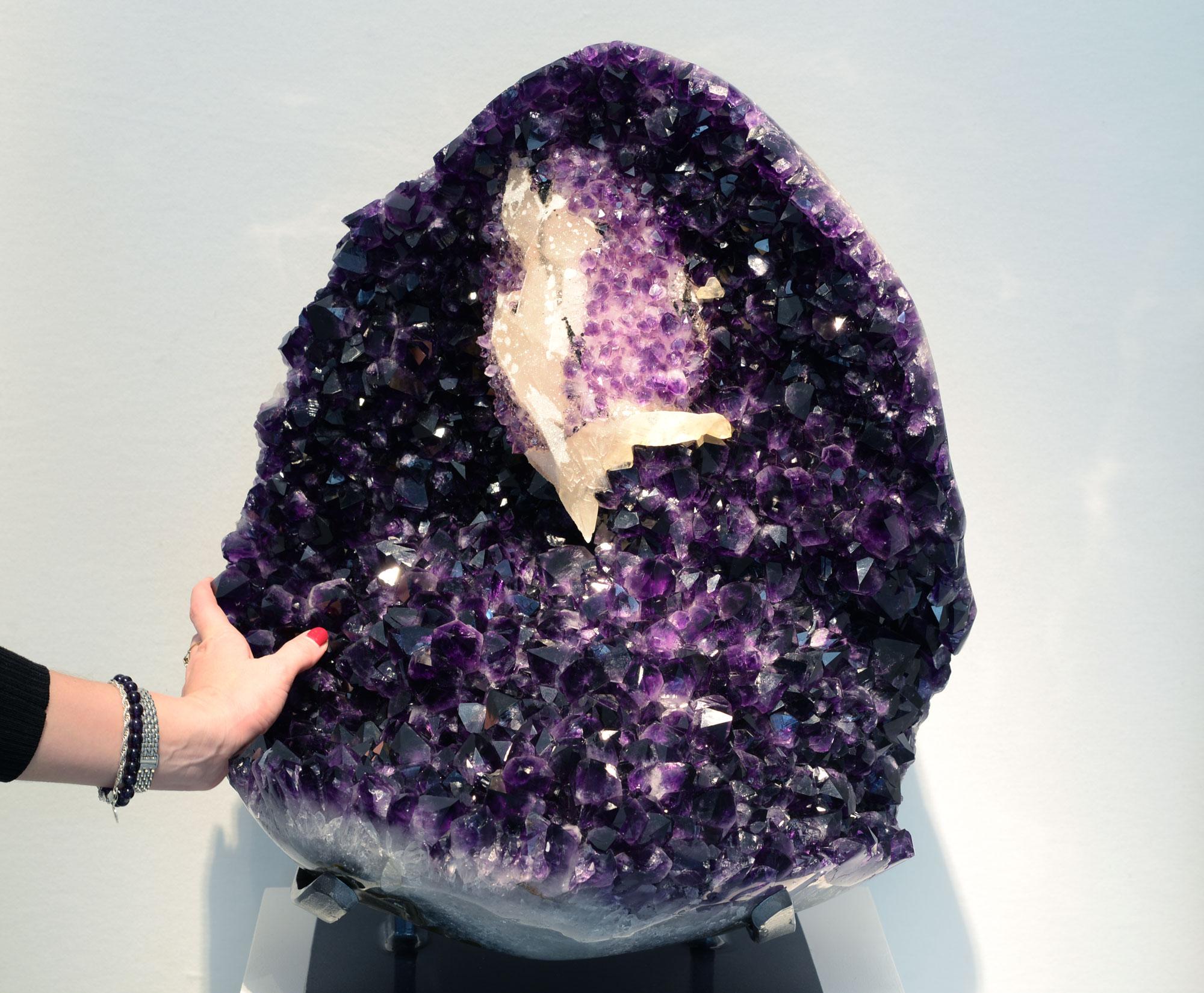 A breath-taking large Uruguayan amethyst cluster with large, amethyst-overlaid calcite formation at the top.

This formation is unusual for its overall scale and the extremely high quality of its intense violet amethyst crystals. Furthermore, the