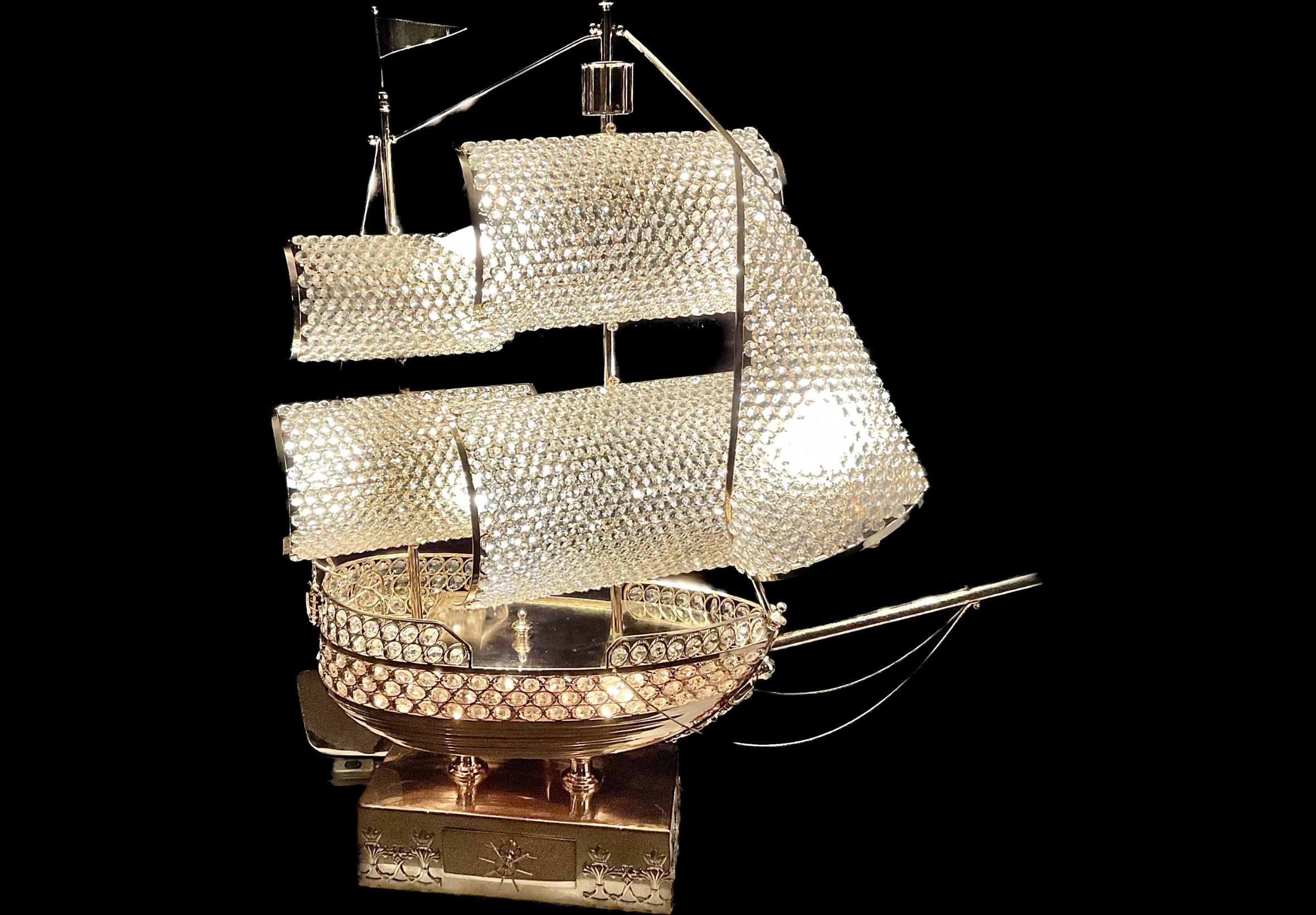 Exceptional and Unique rare large French gilt and crystal sailing ship lamp. Thirteen socket electric figural lamp fashioned as a gilt ship hung with crystal bead sails. Mounted on a base containing a drawer with a ship's wheel handle. Wired with