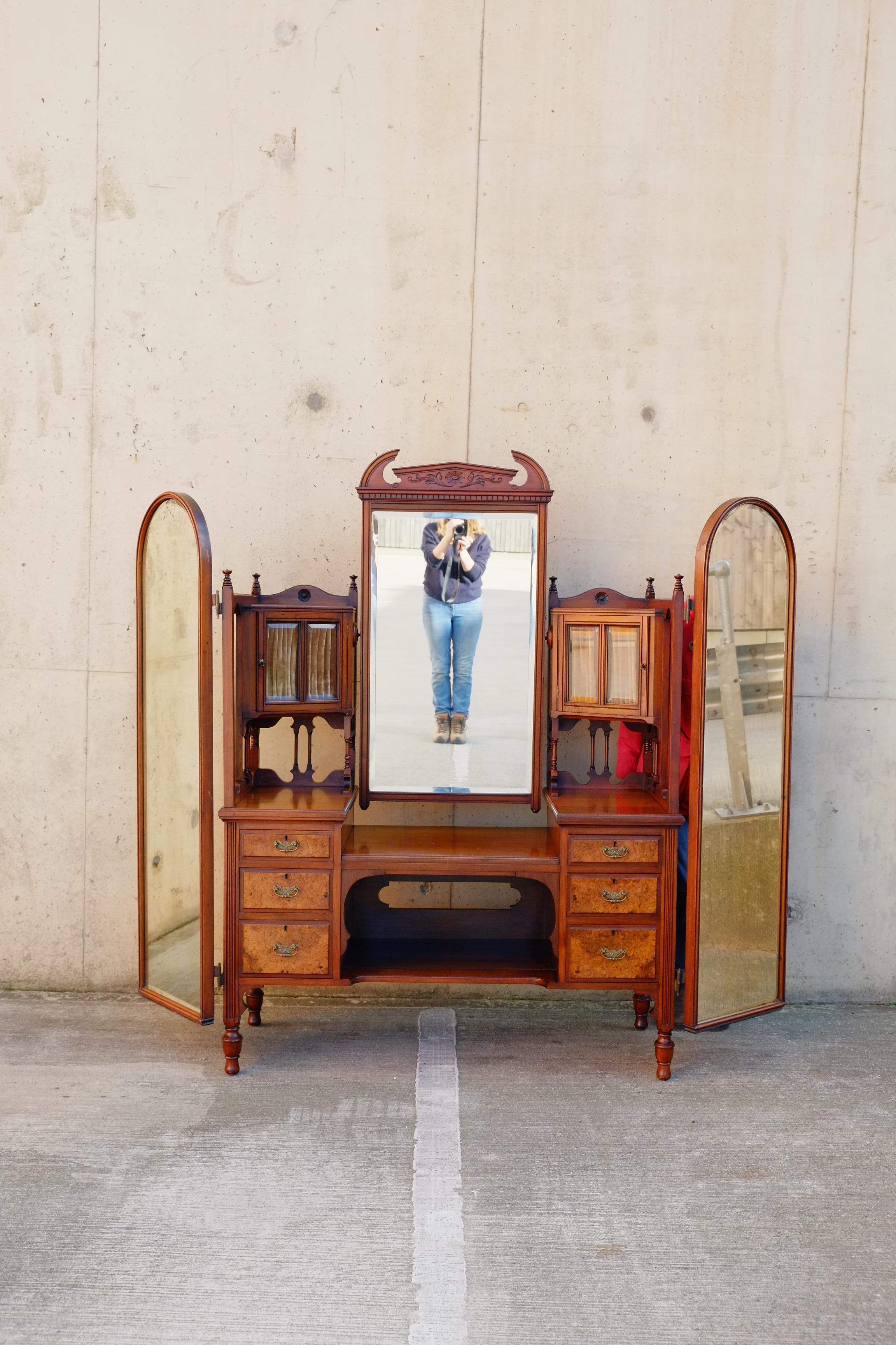 An exceptional large vanity with six drawers, two cabinets and triple dressing mirrors. Circa 1900's. Made in England to the highest quality with fully panelled wooden back mirrors, beautiful craftsmanship in mahogany and burr walnut. This vanity