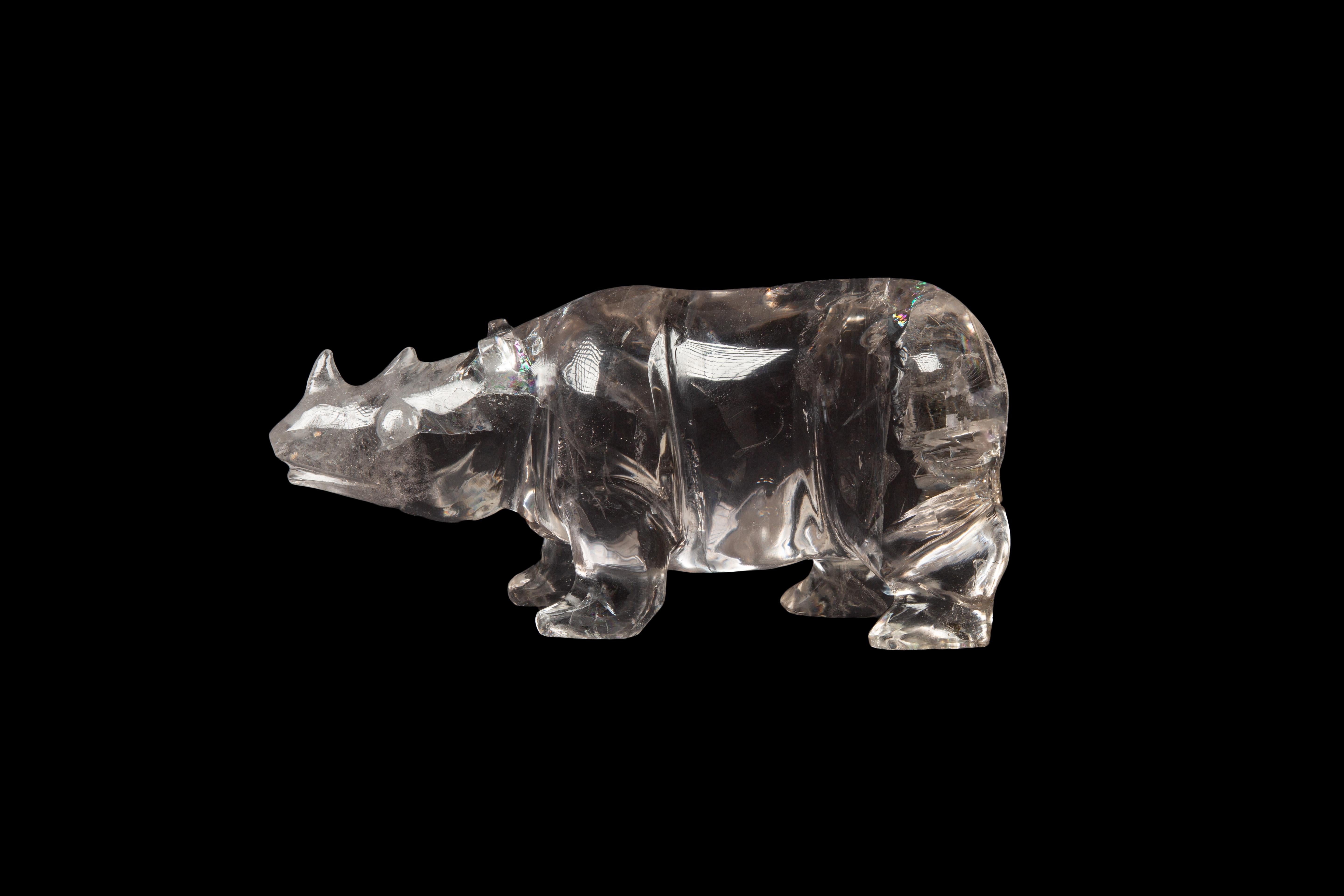 Cet exceptionnel rhinocéros en cristal de roche (quartz) sculpté à la main est une magnifique œuvre d'art qui témoigne de l'habileté et du savoir-faire de son créateur. D'une hauteur de 4 pouces, d'une largeur de 3 pouces et d'une longueur de 8