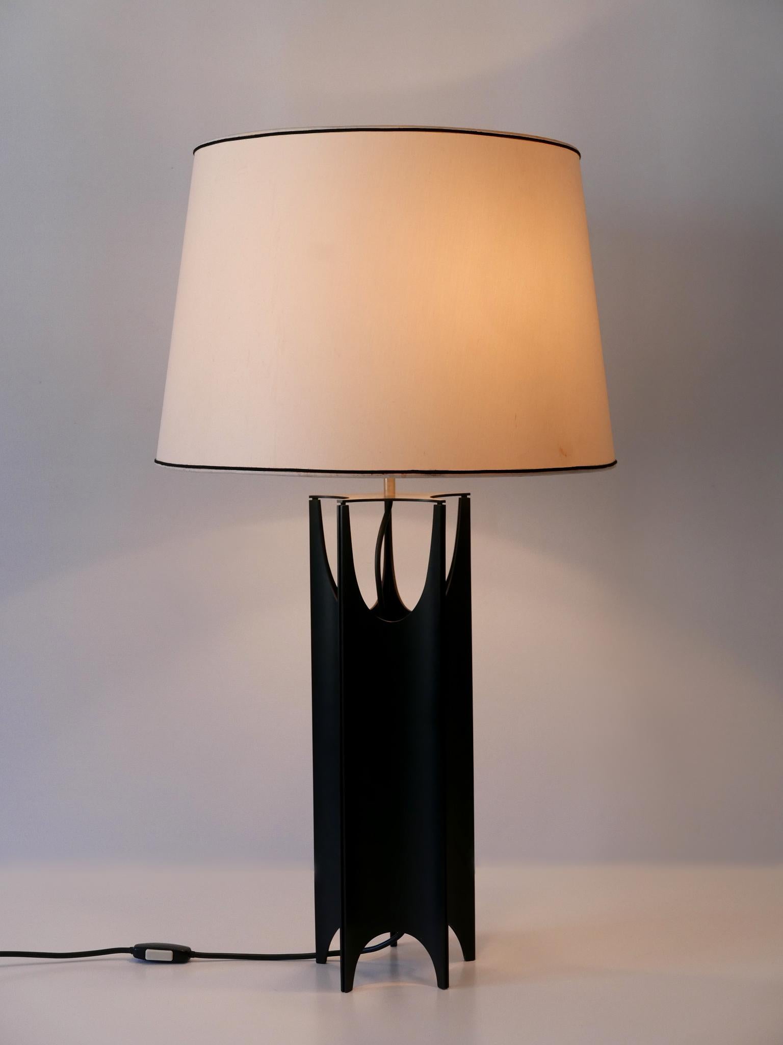 Extrêmement rare, élégante et grande lampe de table brutaliste de style Mid-Century Modern. Conçu et fabriqué en Italie, dans les années 1960.

Réalisée en métal peint noir, la lampe de table est livrée avec 2 ampoules à vis Edison E27 / E26, est