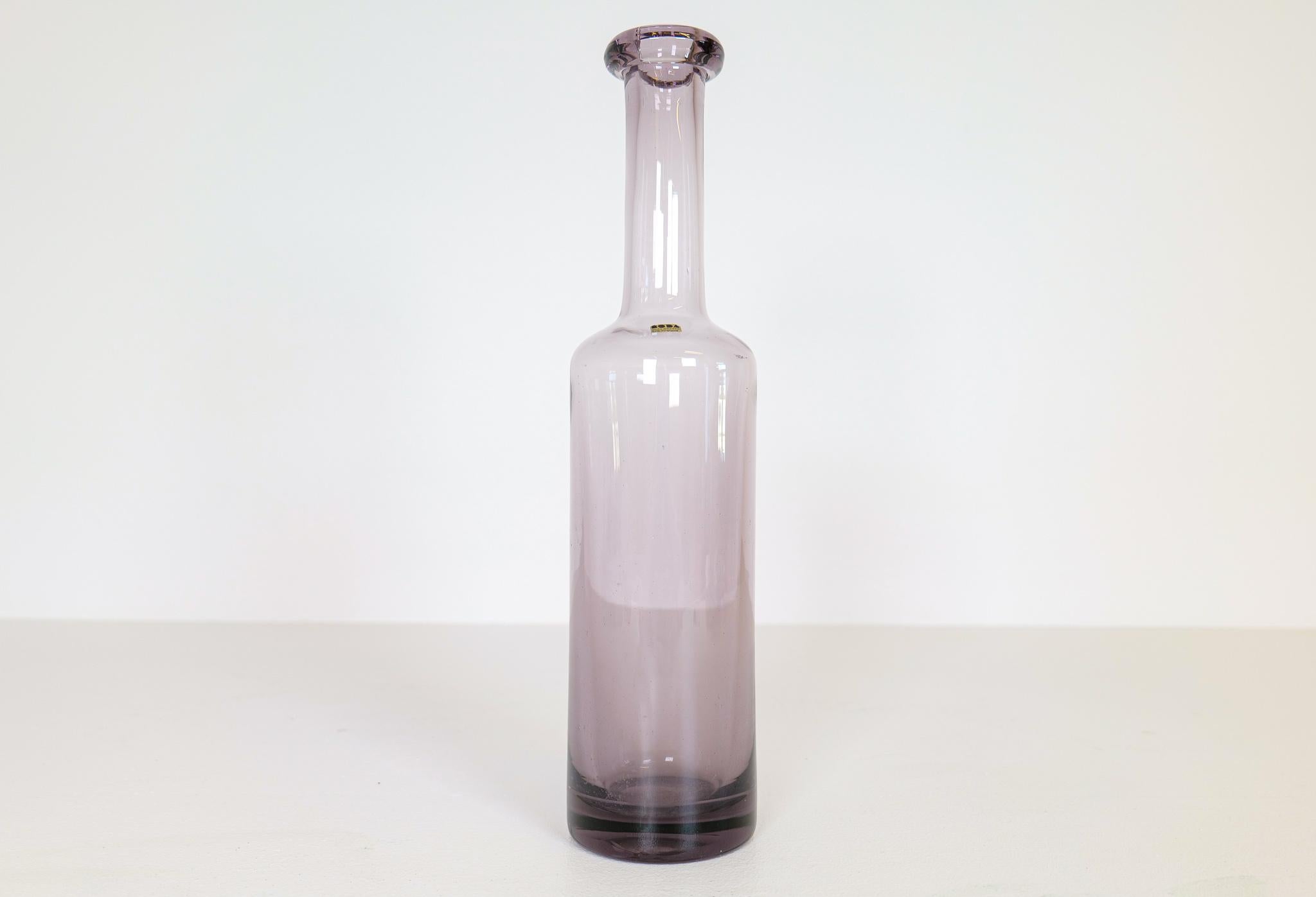 This large bottle was made at Boda and designed by Erik Höglund in Sweden, 1960s.
The bottles light purple color gives the glass that wonderful art shine. It’s a large piece consider its form as bottle and a very rare piece to come by.

Very good