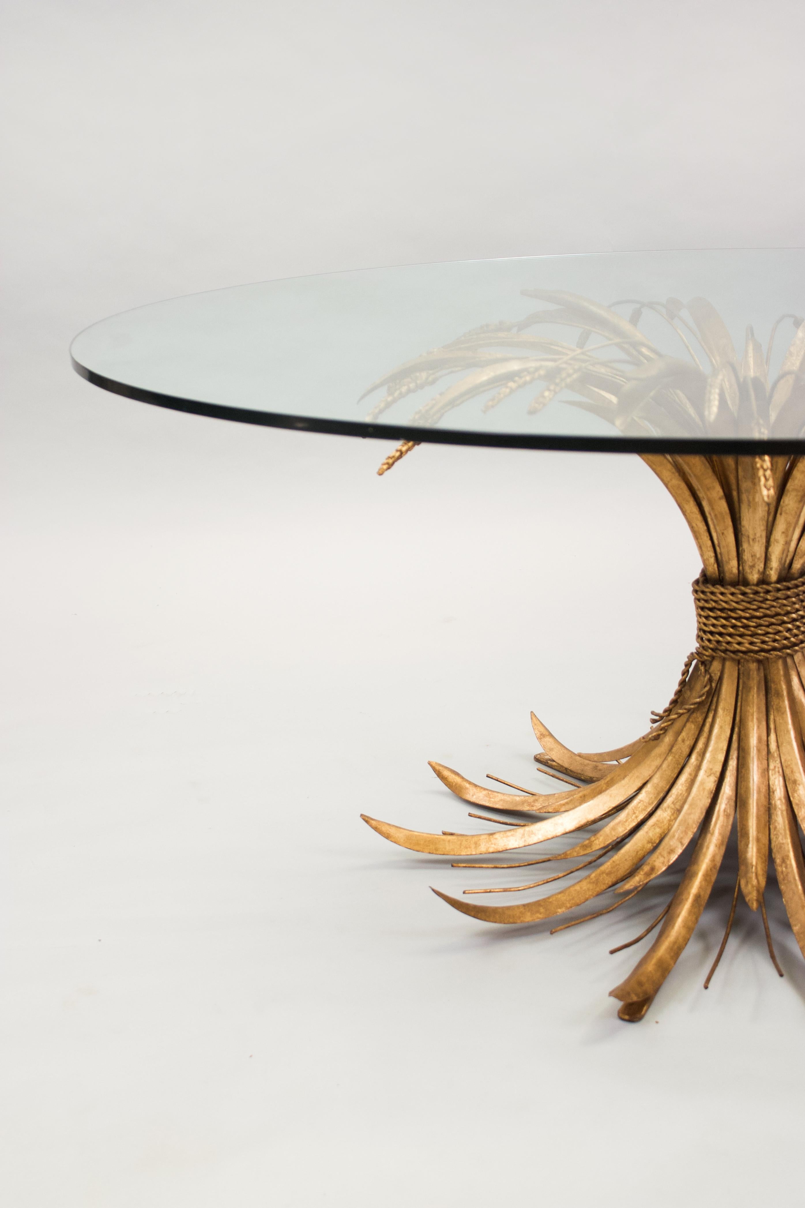 Ein außergewöhnlich großer, runder, niedriger Tisch aus vergoldetem Metall, der eine Weizengarbe darstellt, mit Glasplatte. Circa 1960. Ähnlicher Tisch im Appartement von Coco Chanel. 

Abmessungen
u2028H 57cm (22