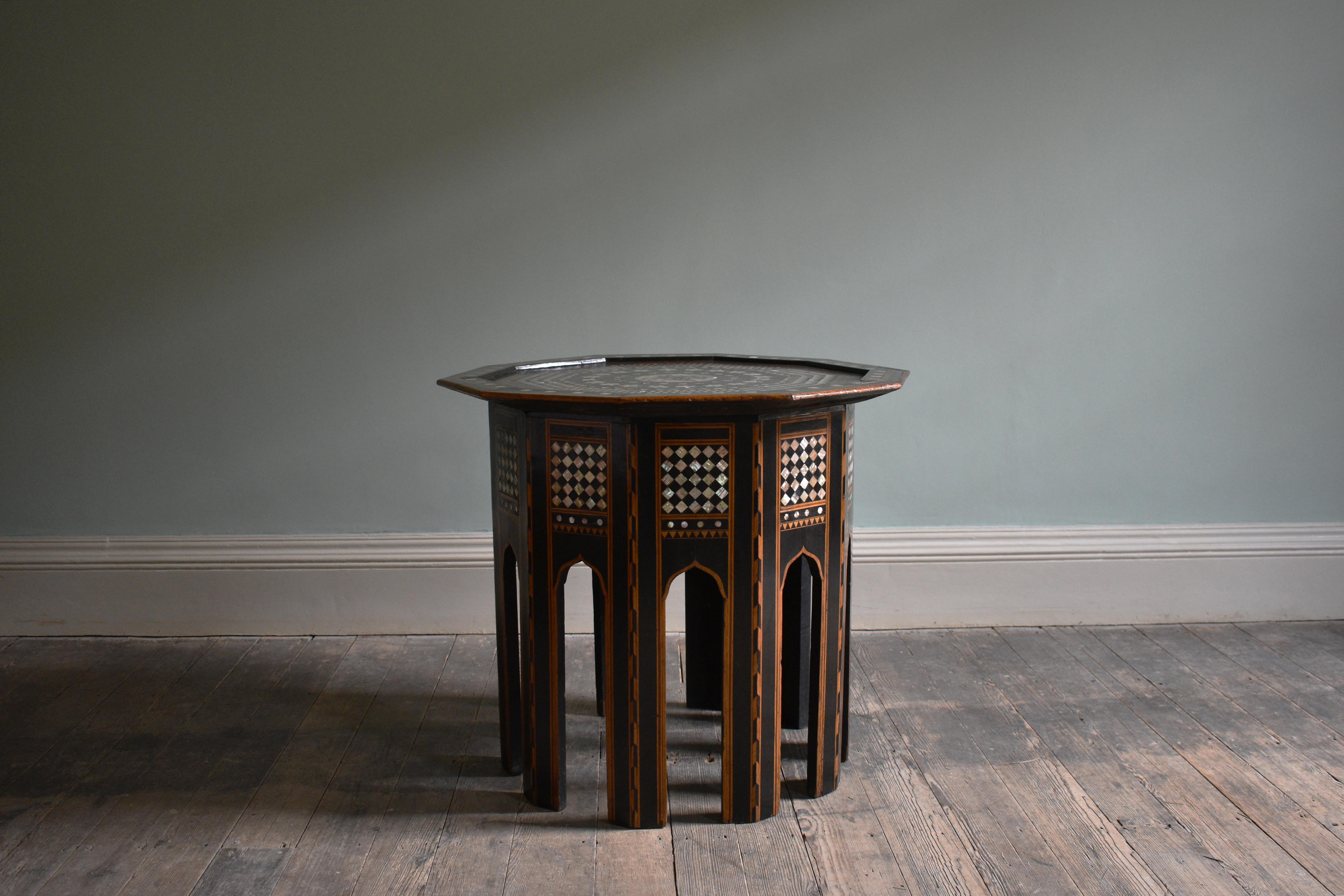 An exceptional, large Syrian occasional table.

Mother of pearl, bone inlay and wood. A Syrian mother of pearl, bone and marquetry inlaid occasional table. With script to the centre of a geometric-marquetry faceted top on a conforming