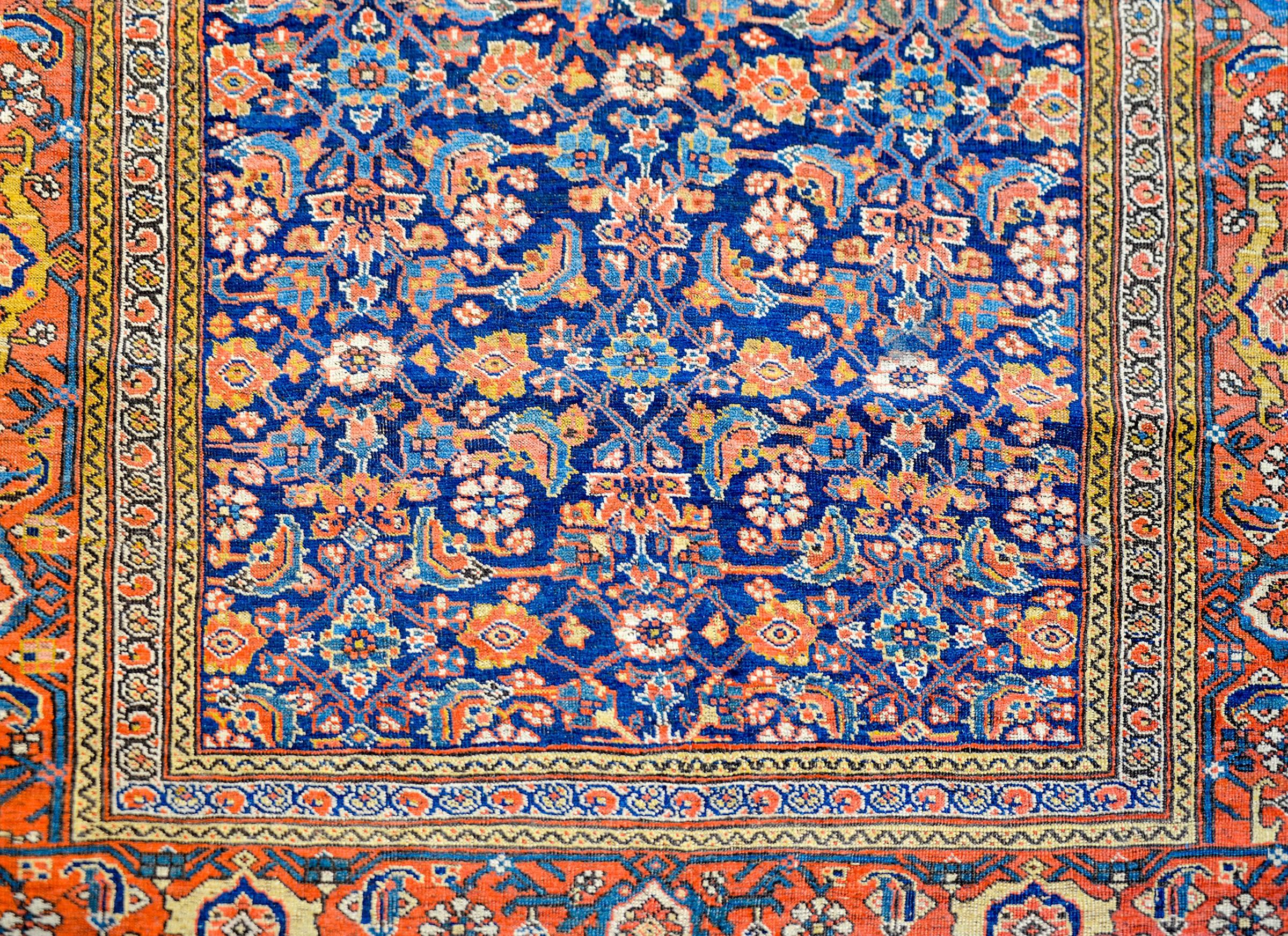 An exceptional late 19th century Persian Bidjar rug with a fantastic central field composed with a floral and vine trellis pattern rendered in brilliant crimson, gold, light indigo and cream colored vegetable dyed wool, on a bold dark indigo