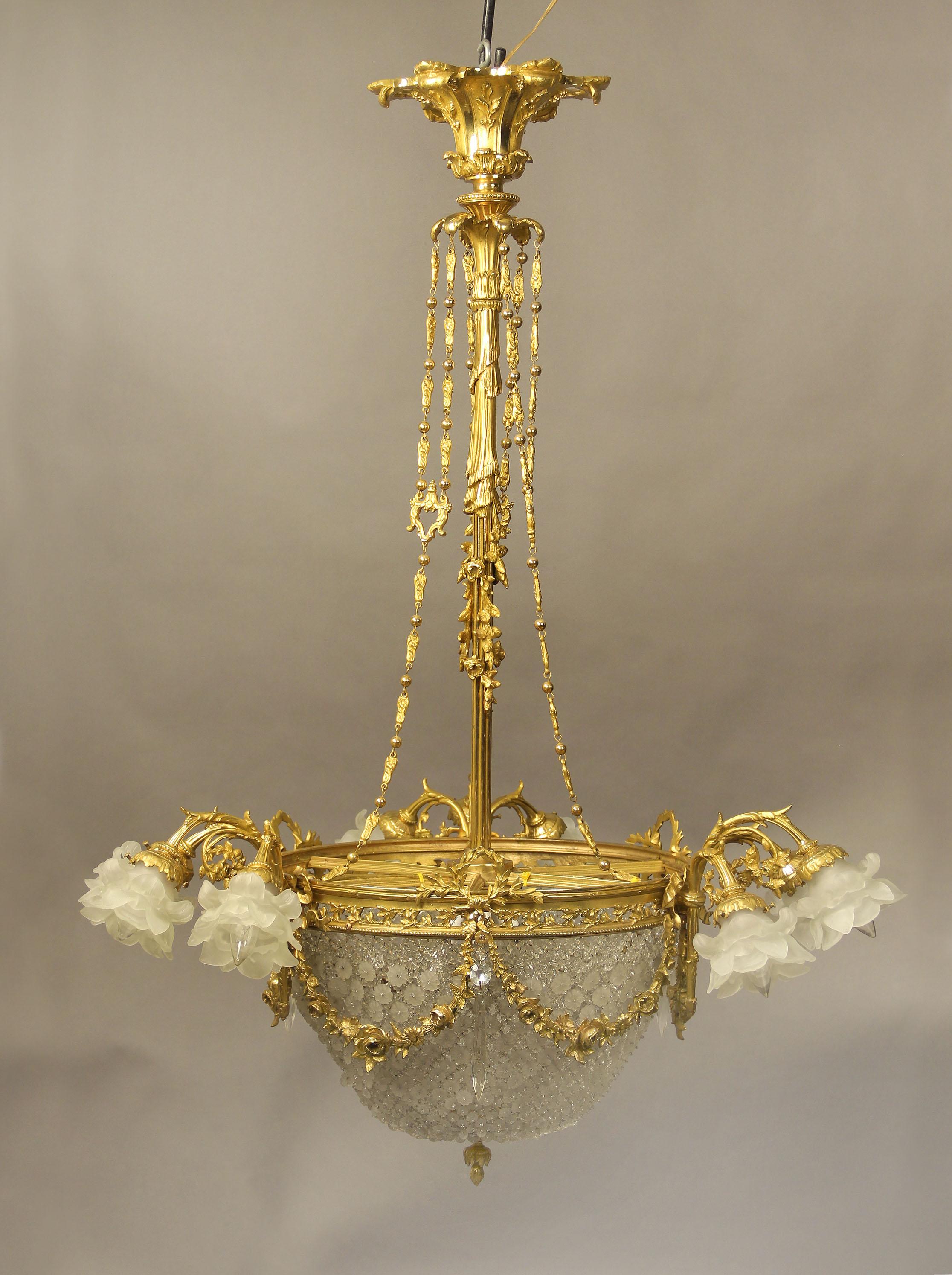 An exceptional late 19th century gilt bronze and crystal fourteen light basket chandelier.

The crown connected to the body by a long, floral and curtain designed stem with three sets of bronze ropes. The crystal basket is mounted by flower and