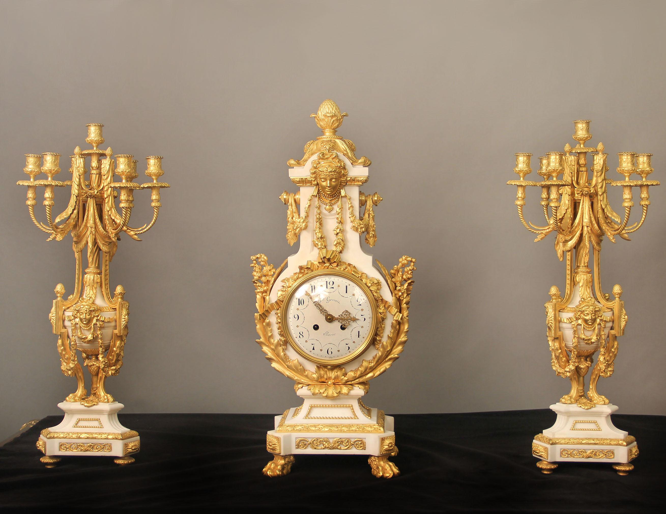 An exceptional late 19th century gilt bronze-mounted marble three-piece clock set

By Ferdinand Gervais

The lyre shaped case surrounded with bronze roses, acanthus and lilys, a large female mask with berried swags adorns the front and back of