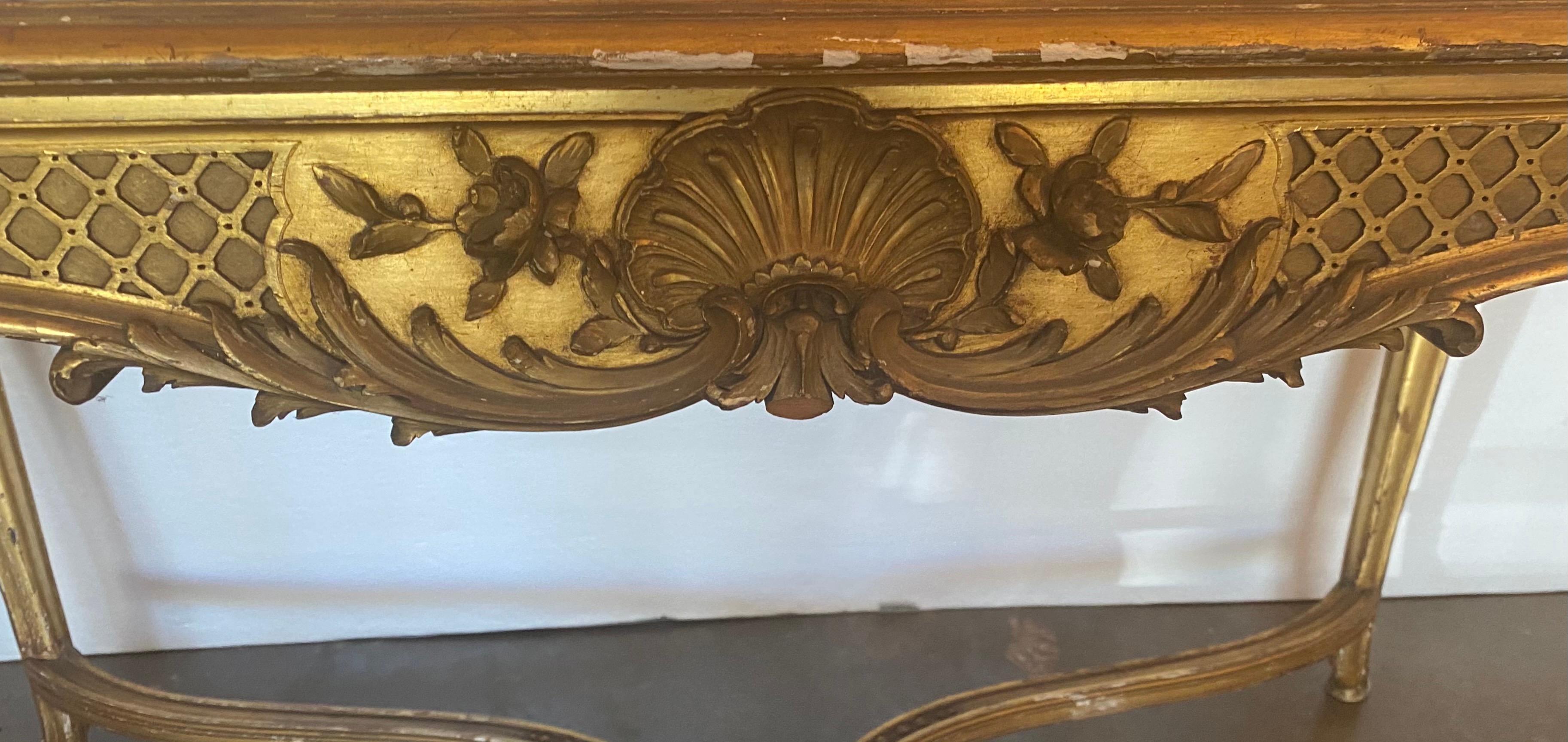 Außergewöhnlicher Tisch mit vergoldeter Marmorplatte im Louis XV-Stil, Mitte 19. Jh., mit geformter, eingelassener Marmorplatte, über einer geschnitzten Schürze mit Blattwerk- und Muschelmotiven, auf Kabriole-Beinen, die durch eine X-Brücke