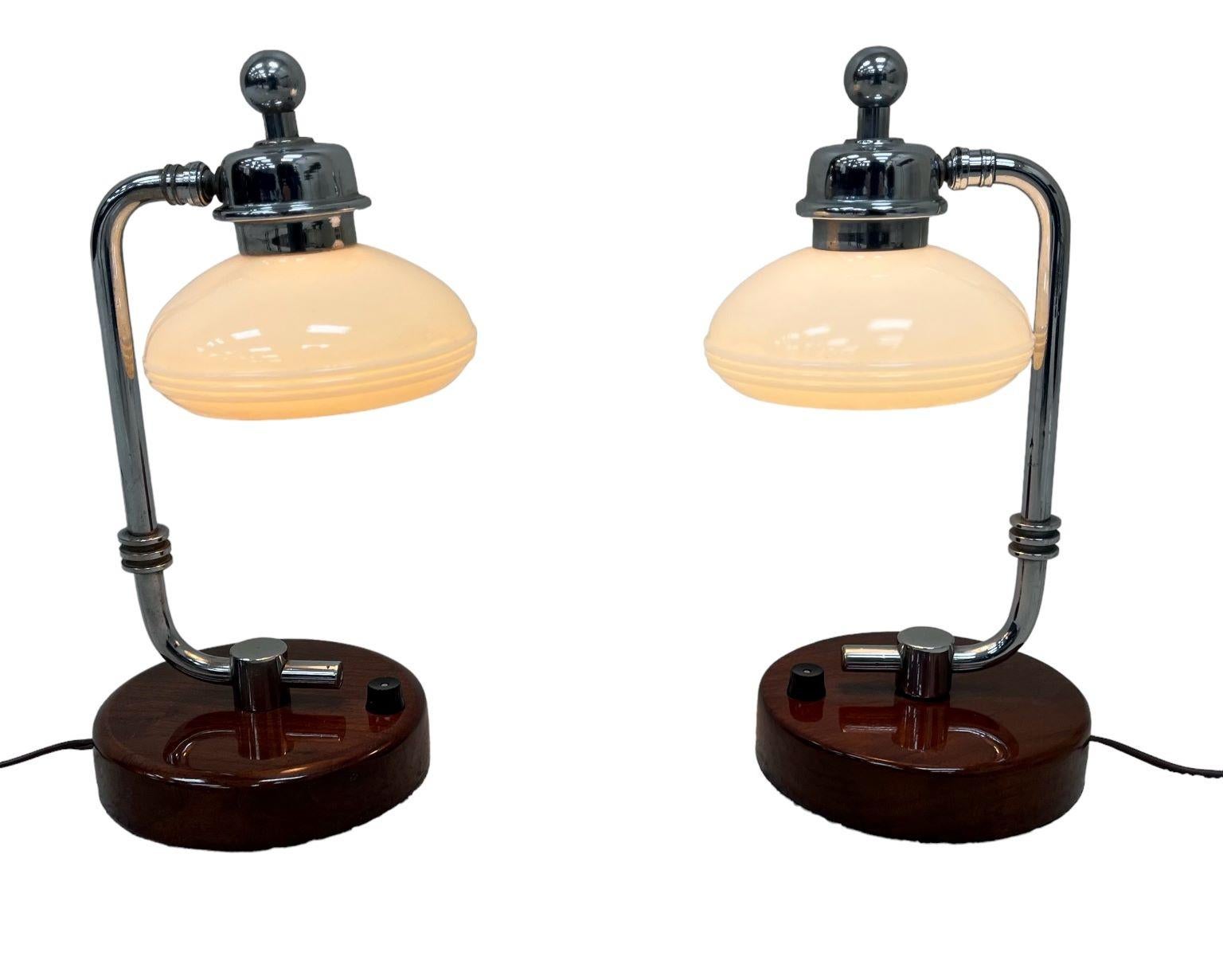 Rare pair of Machine Age Art Deco walnut and polished chrome table lamps. A simple streamline design from the American Art deco movement of the 1930’s. Professionally restored and rewired. Dimensions 13 inches high, base is 6 inches in diameter, and