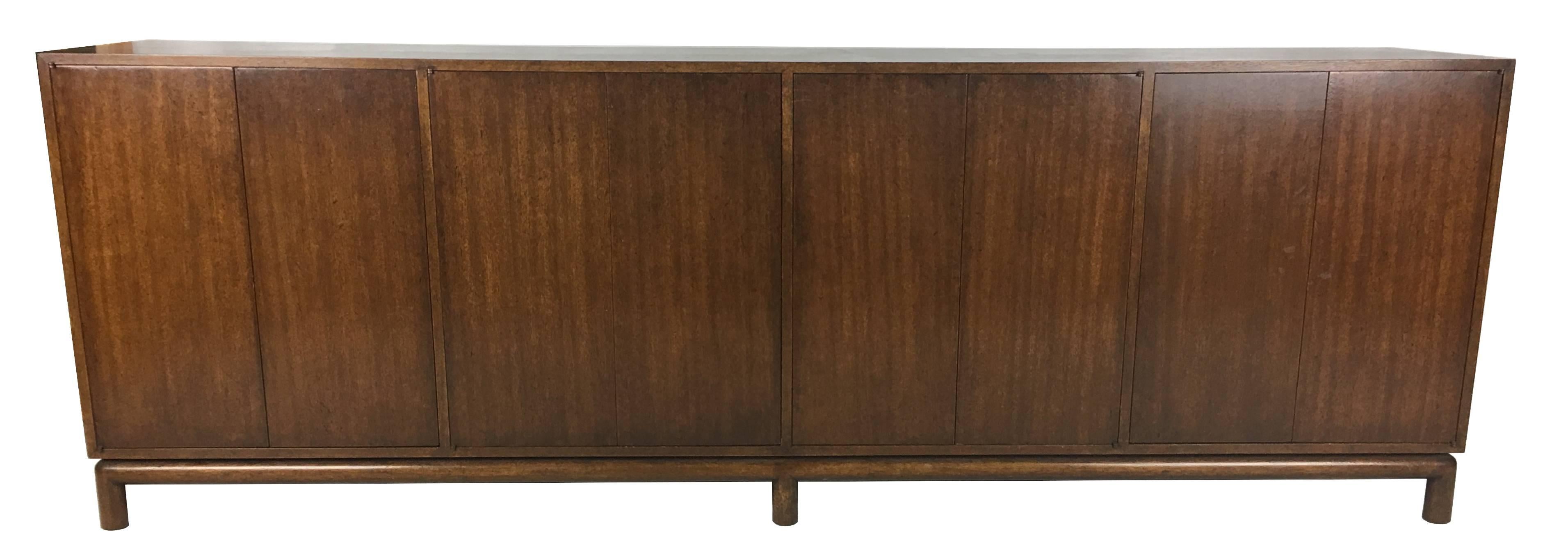 Beautifully crafted Mahogany Sideboard raised on a dowel-legged base. This thin-edged piece has four bi-fold door compartments; two are fitted with drawers and felt lined silver storage and the remaining two are fitted with two adjustable shelves
