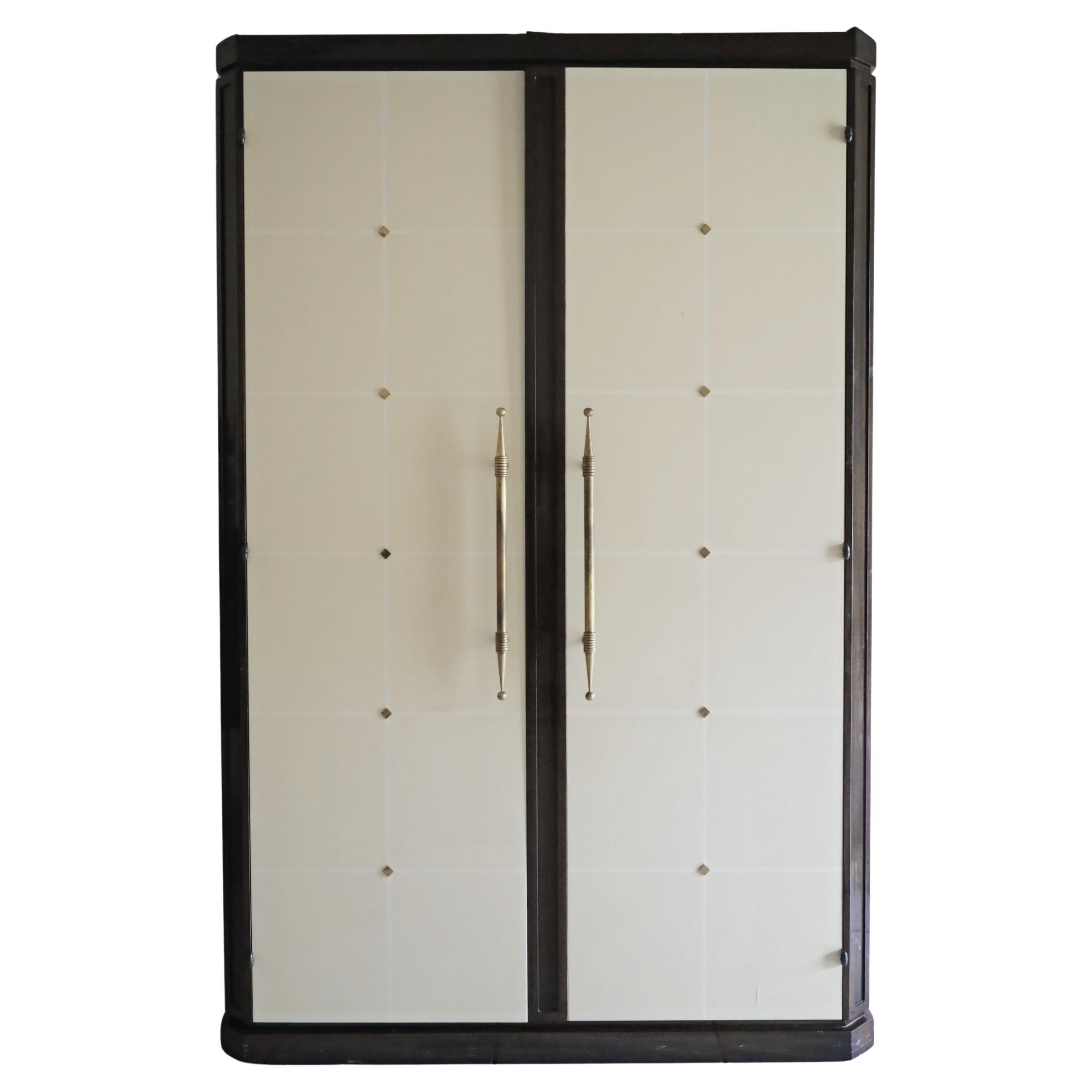Exceptionnelle armoire en acajou + laque ivoire ornée de laiton de Tommi Parzinger en vente