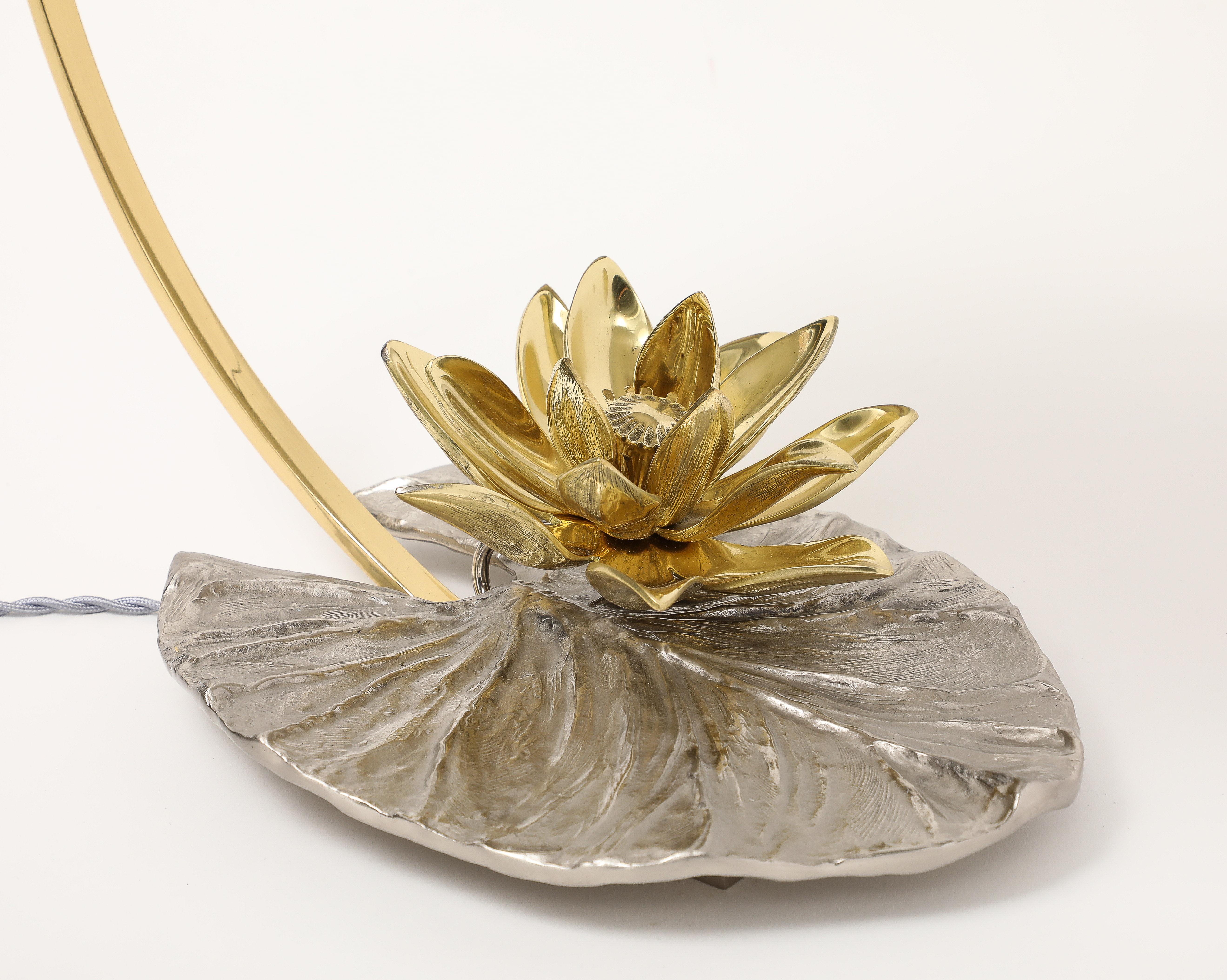 Se trata de una lámpara emblemática de la Maison Charles. El nenúfar fue la inspiración. Esta lámpara es especialmente rara.  La flor, que es de bronce, se doró, mientras que la superficie de la lámpara se plateó. Fue alambrada en EE.UU. y reacabada