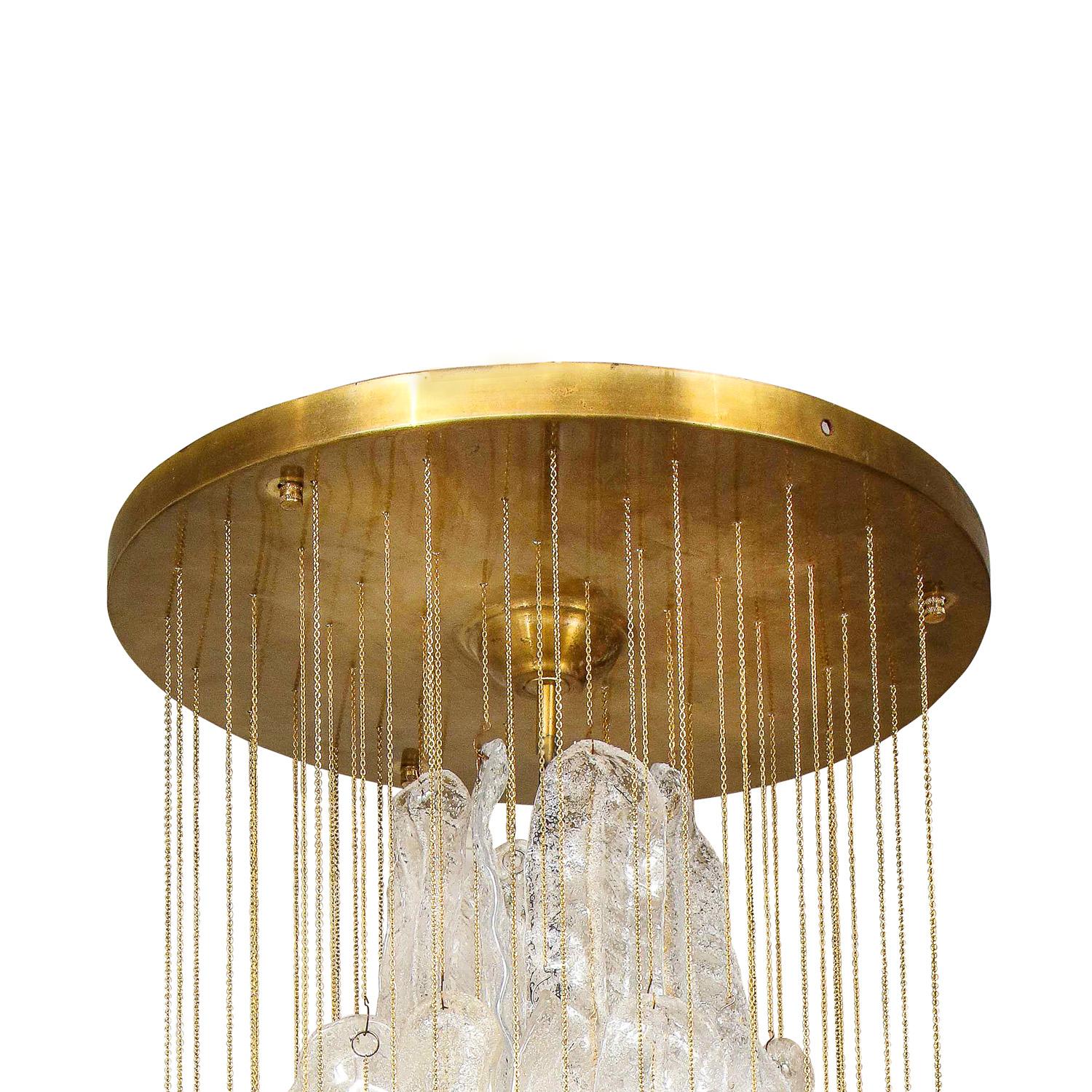 Large Mazzega Murano clear and gold glass feather chandelier with brass suspensions and canopy. Italy, 1960's Sold individually. There are currently two available.