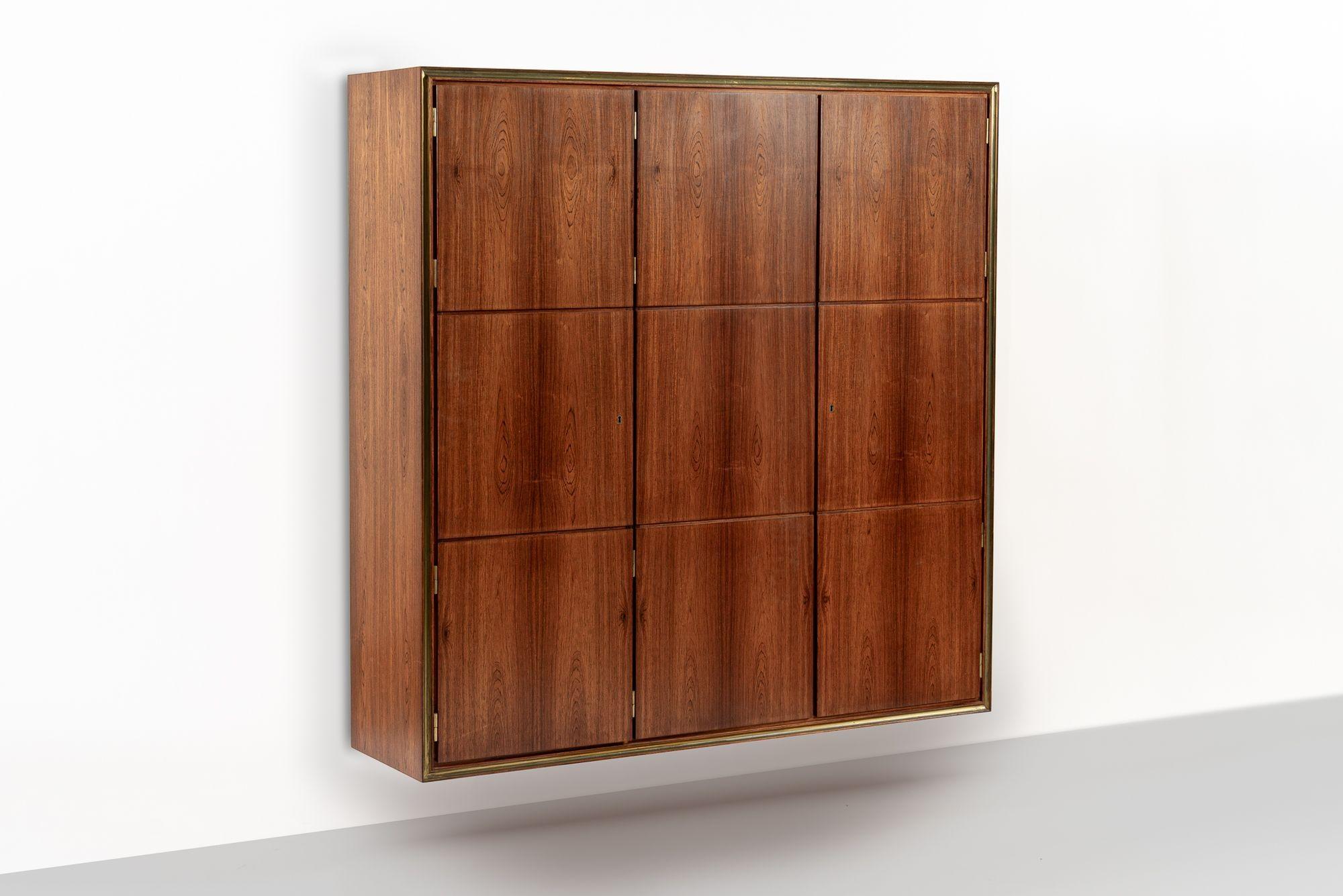 Este impresionante armario-estantería vintage de palisandro danés de mediados de siglo fue diseñado por el arquitecto danés Bent Helweg-Møller y fabricado por el ebanista Jacob Kjær hacia 1950. Este raro armario está diseñado para flotar en la pared