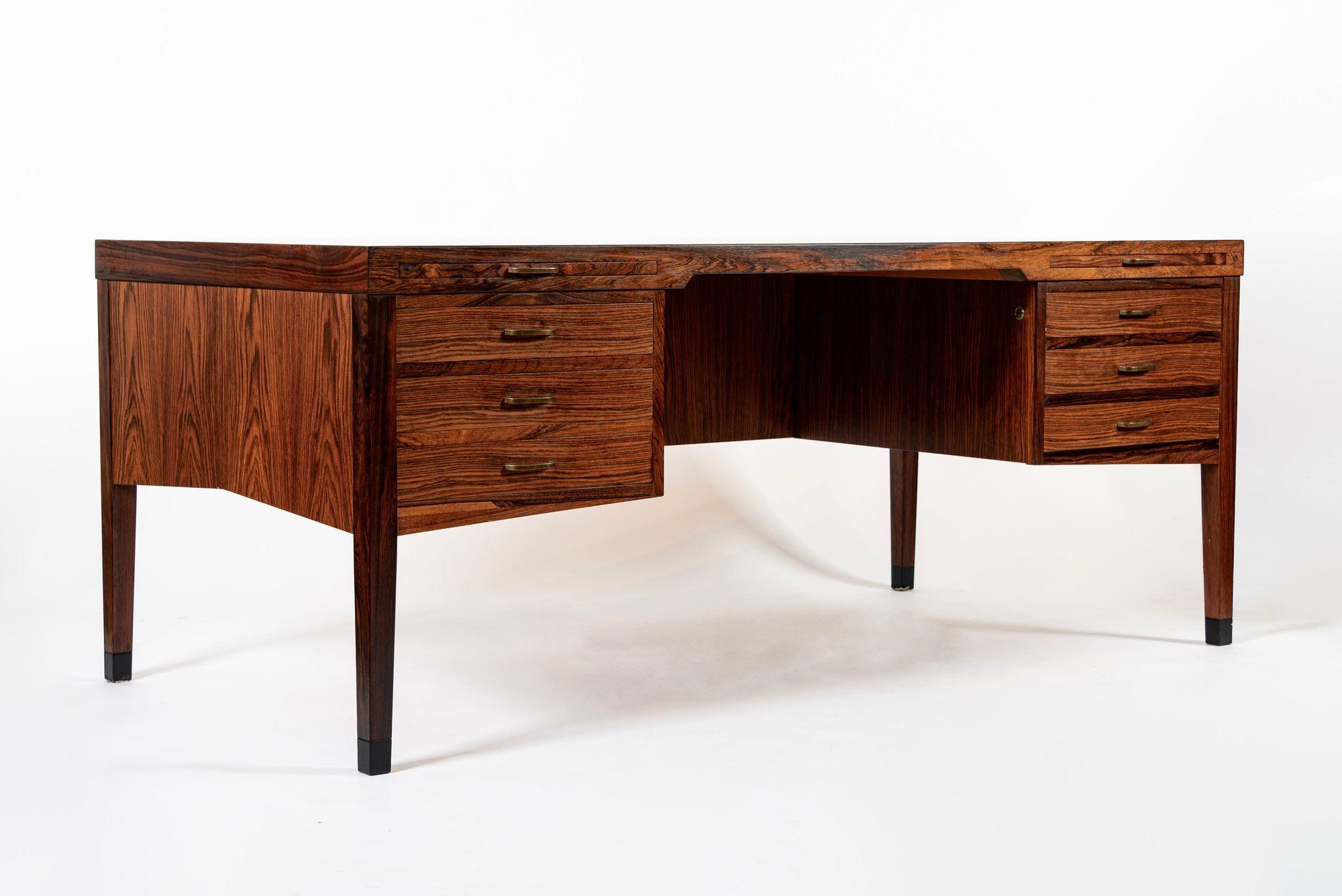 This exceptional vintage mid century Danish modern rosewood desk was made in Denmark circa 1960. This large executive desk has a classic Danish modern design with clean, minimalist lines and is well-crafted from rosewood with beautiful wood grain