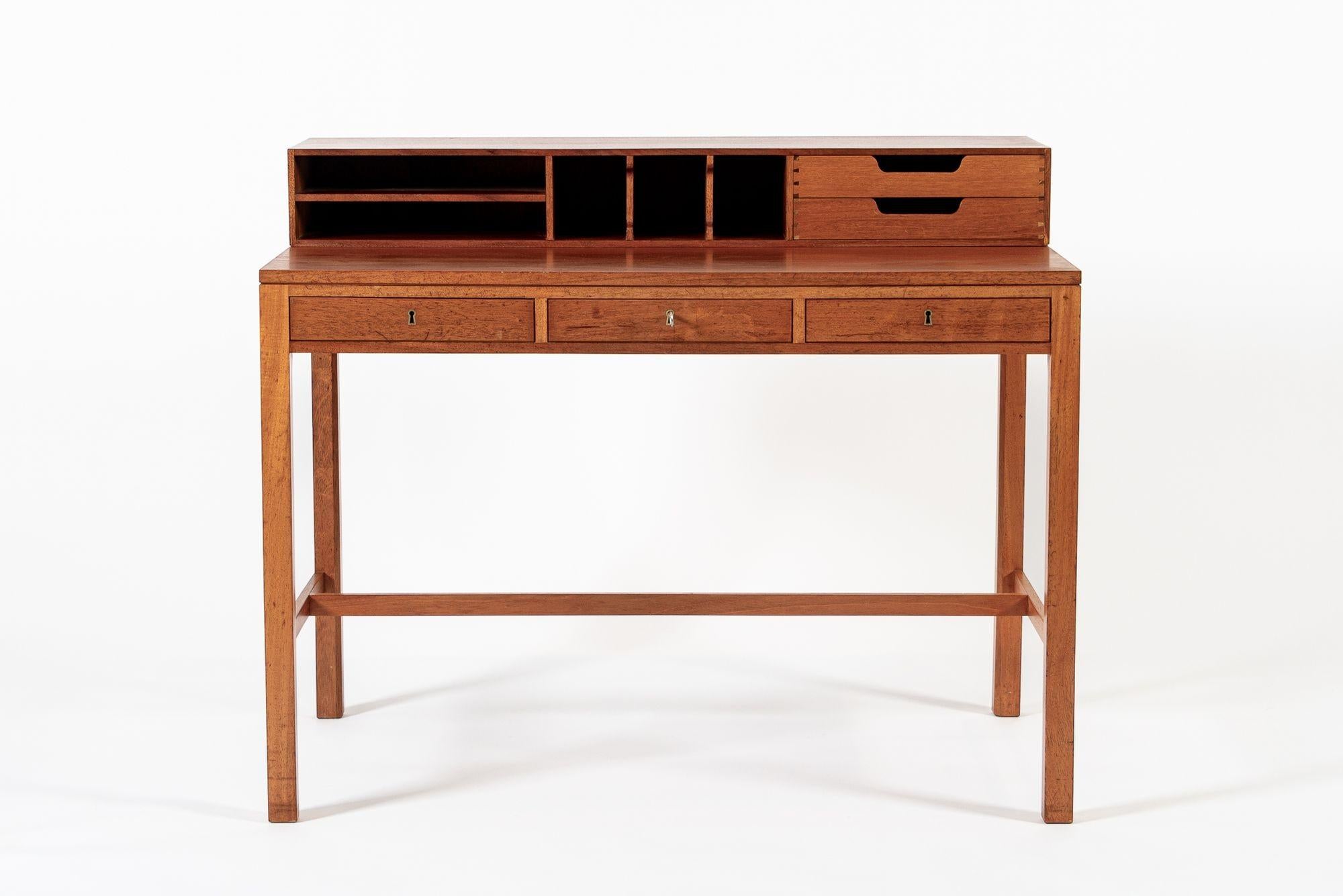 Questo eccezionale scrittoio danese moderno di metà secolo in legno di teak e mogano, con conigliera, è stato realizzato in Danimarca nel 1960 circa. Il mobile è ben realizzato in legno di teak con accenti di mogano e presenta una calda tonalità