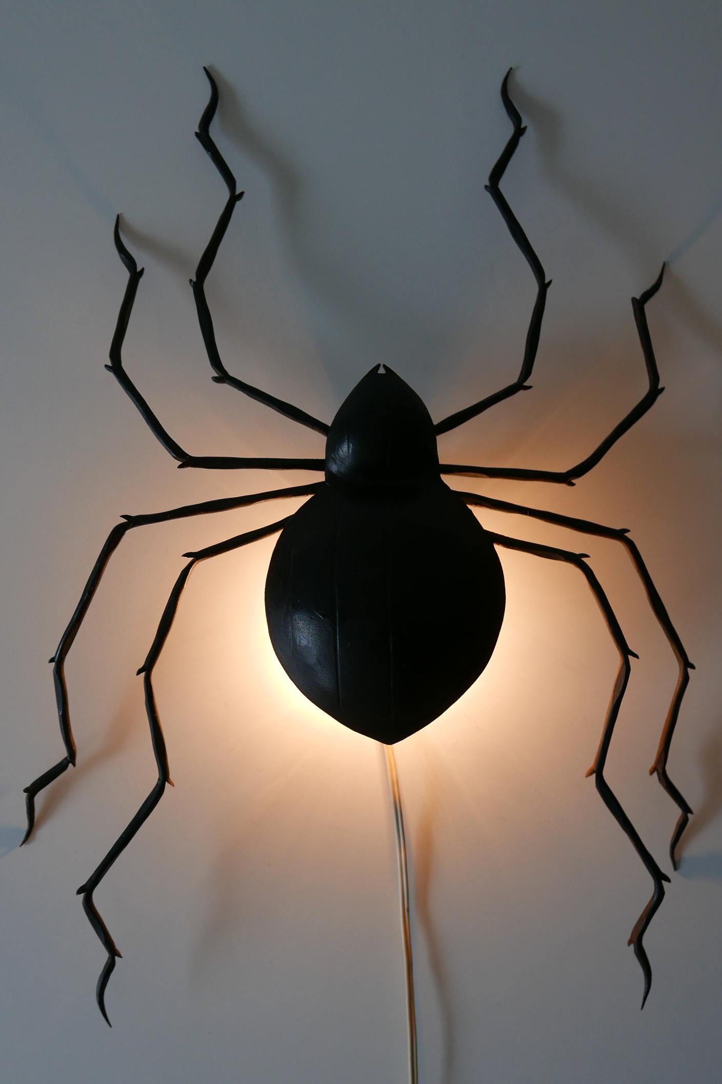 Extremely rare and beautiful Mid-Century Modern wall lamp or sconce in shape of a giant spider. Manufactured probably in 1970s, Germany. With lovely details.

The lamp is executed in black lacquered iron, the lamp needs 1 x E14/E12 Edison screw fit