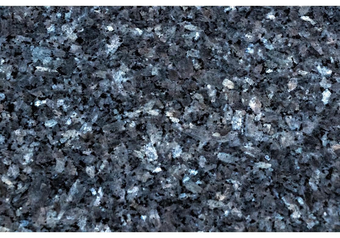 Table de salle à manger ovale classique de style Saarinen avec un remarquable plateau en granit gris à bord chanfreiné.  inclusions de mica réfléchissantes sur l'ensemble du site. Le mica se lit comme de l'argent, et bien que la myriade de pièces