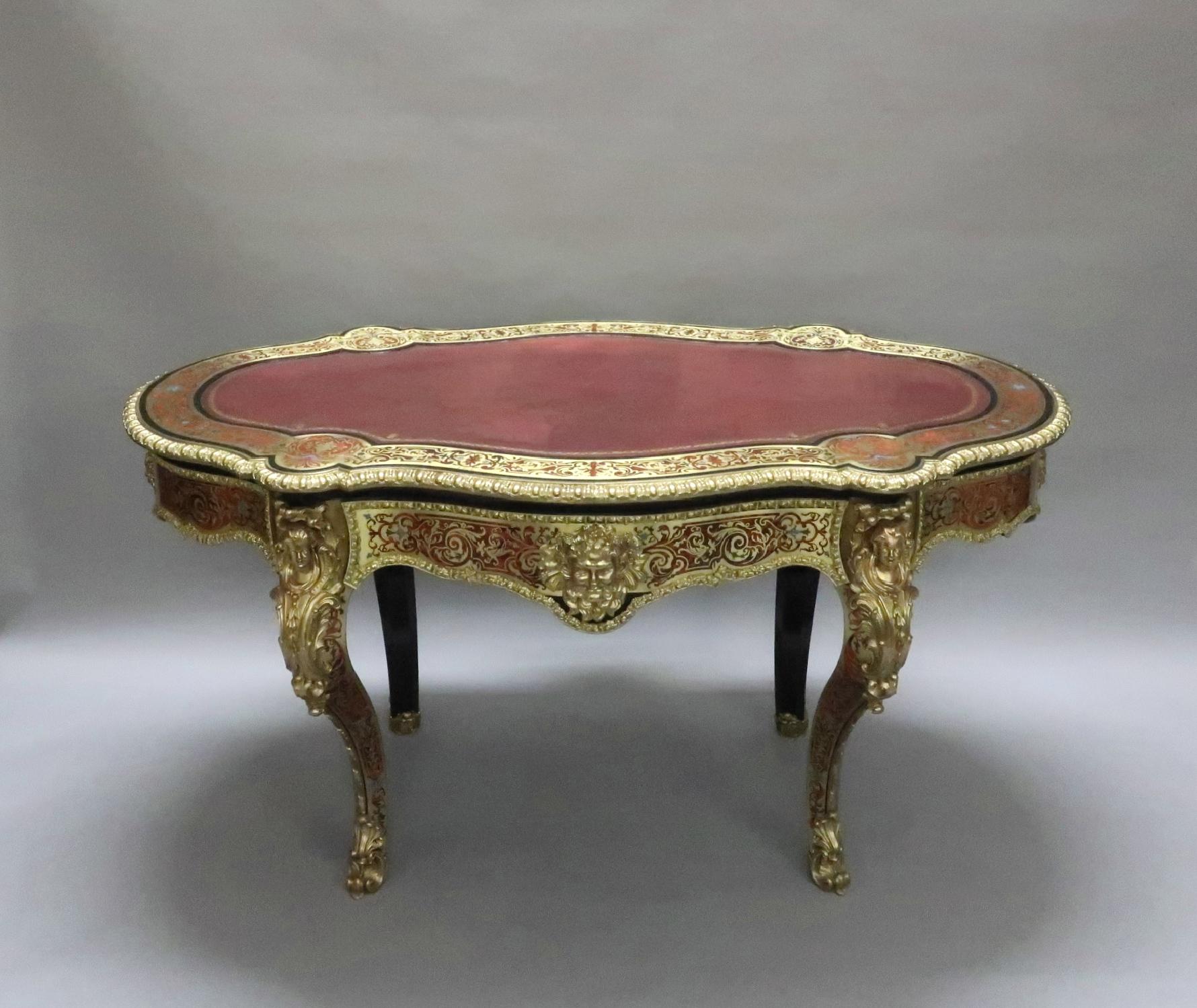 An outstanding exhibition quality freestanding Napoleon III Louis XV style serpentine shaped boulle engraved brass and red tortoiseshell writing table or centre table with blue and green colored enamel inlays. The table still retains its old maroon