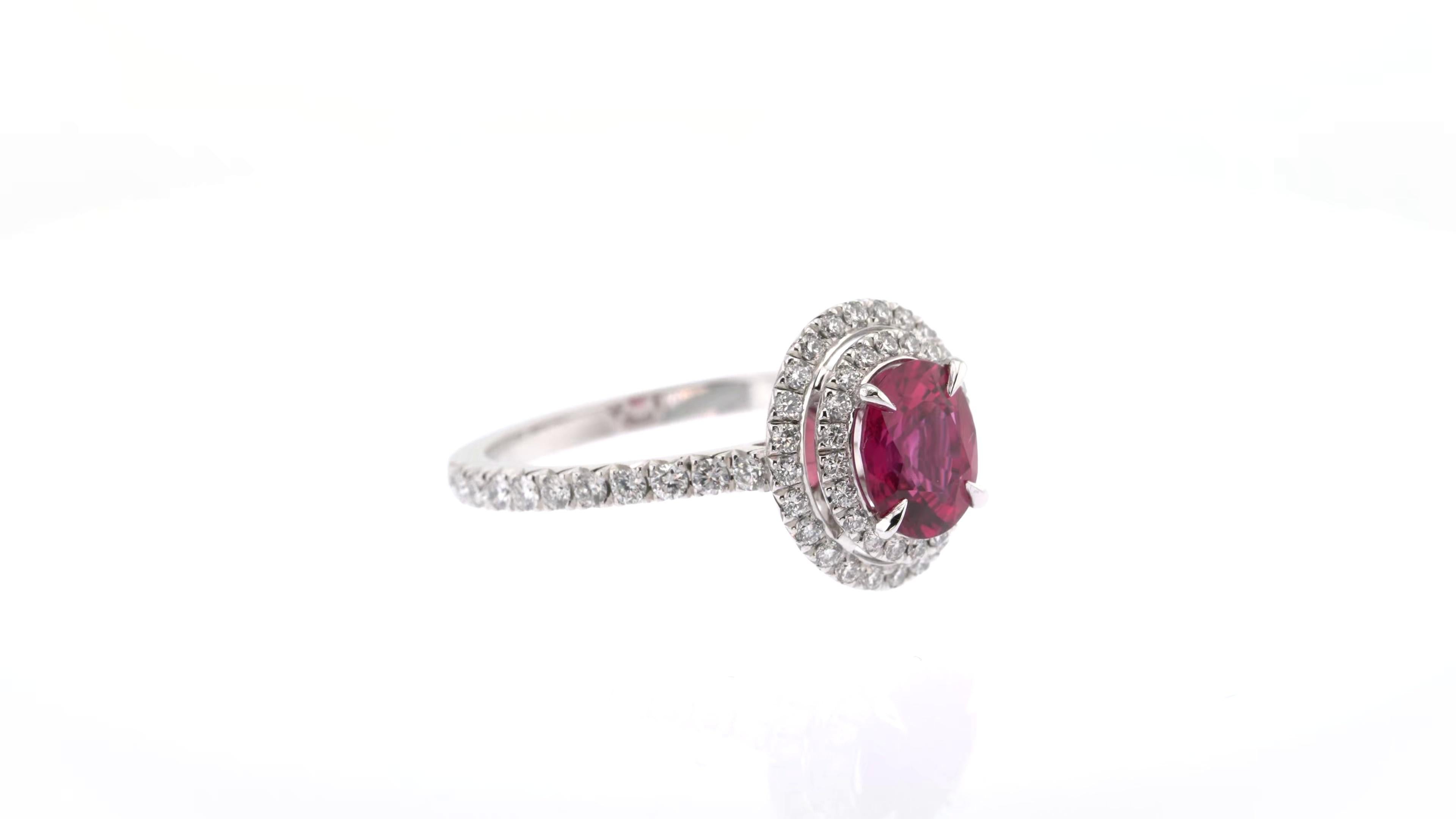 Delicate yet full of life, this elegant ring is made extraordinary by its double halo of white diamonds, which makes it shine as brightly as its wearer. The vivid red ruby at its centre is cut in a classic oval shape and its dazzling diamond
