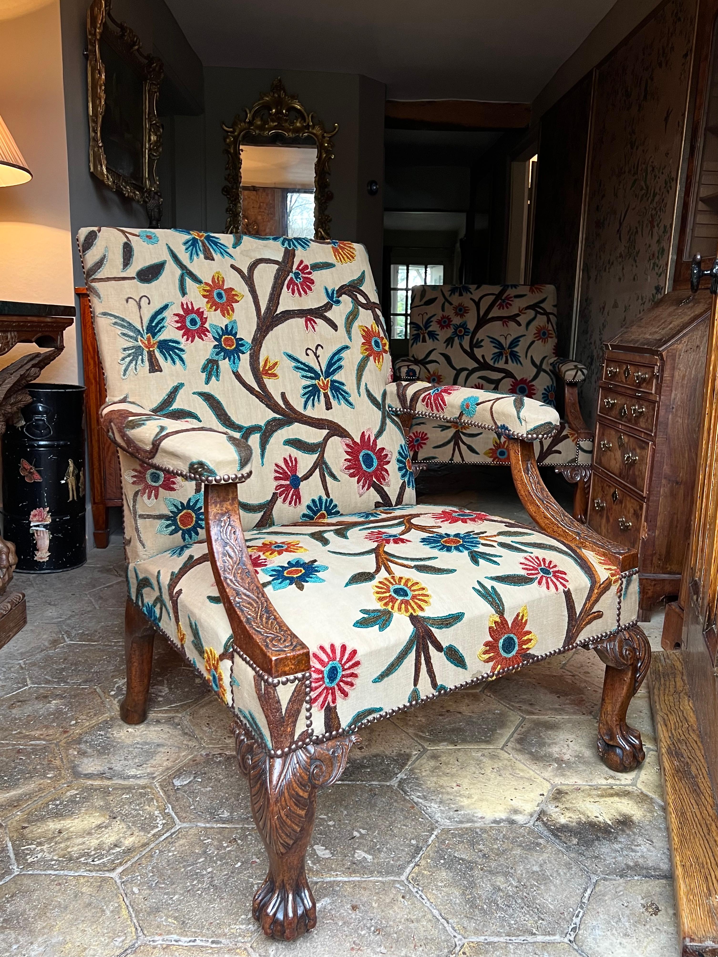 An exceptional pair of English George II-period carved walnut library armchairs.

Raised on very well-carved cabriole legs with stylised ball-and-claw feet, each chair with rectangular upholstered back and padded armrests with down-swept foliate