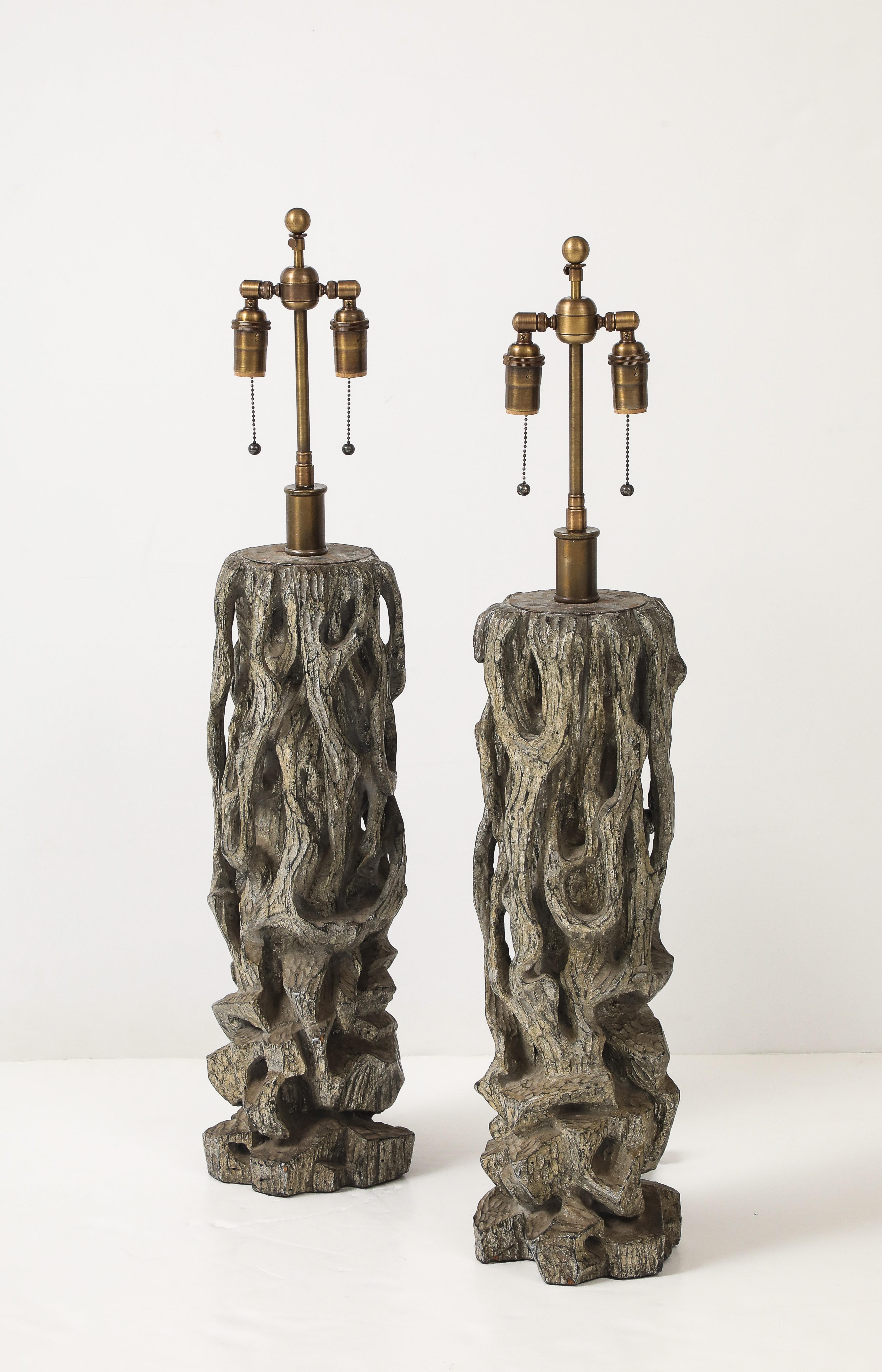 Spectacular pair of 1950's lamps by James Mont.
The wooden carved gnarly tree form lamps have a silvery / grey distressed finish have they been Newly
rewired with adjustable Antiqued brass double clusters and silk rayon cords.
Each socket takes up