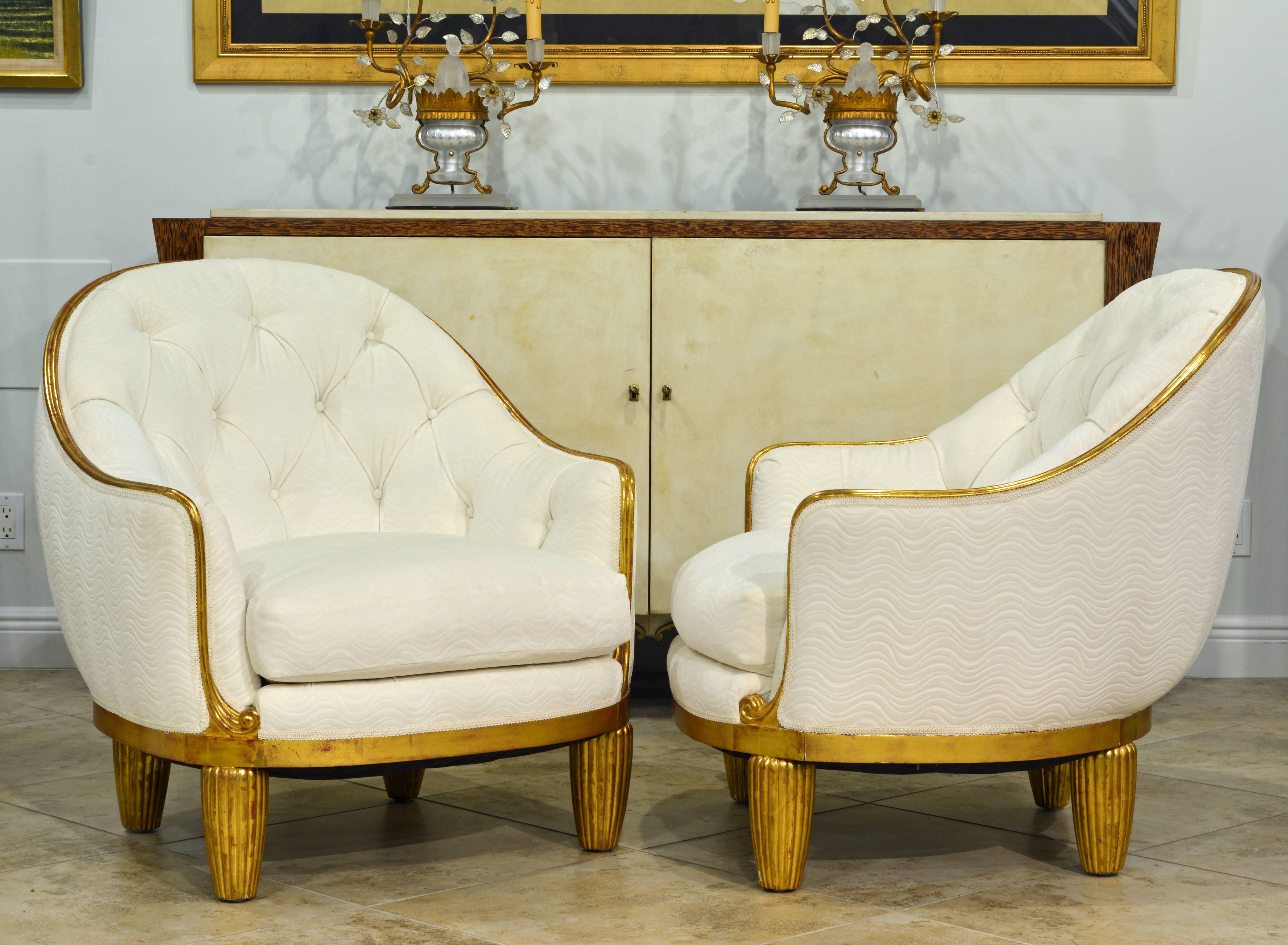 Gently restored to their original glory these wonderful lounge chairs or bergeres, in the style of the legendary furniture designer Maurice Dufrene, feature reeded conical legs typical of Dufrene and a narrow gilded frame in an elegant curvature