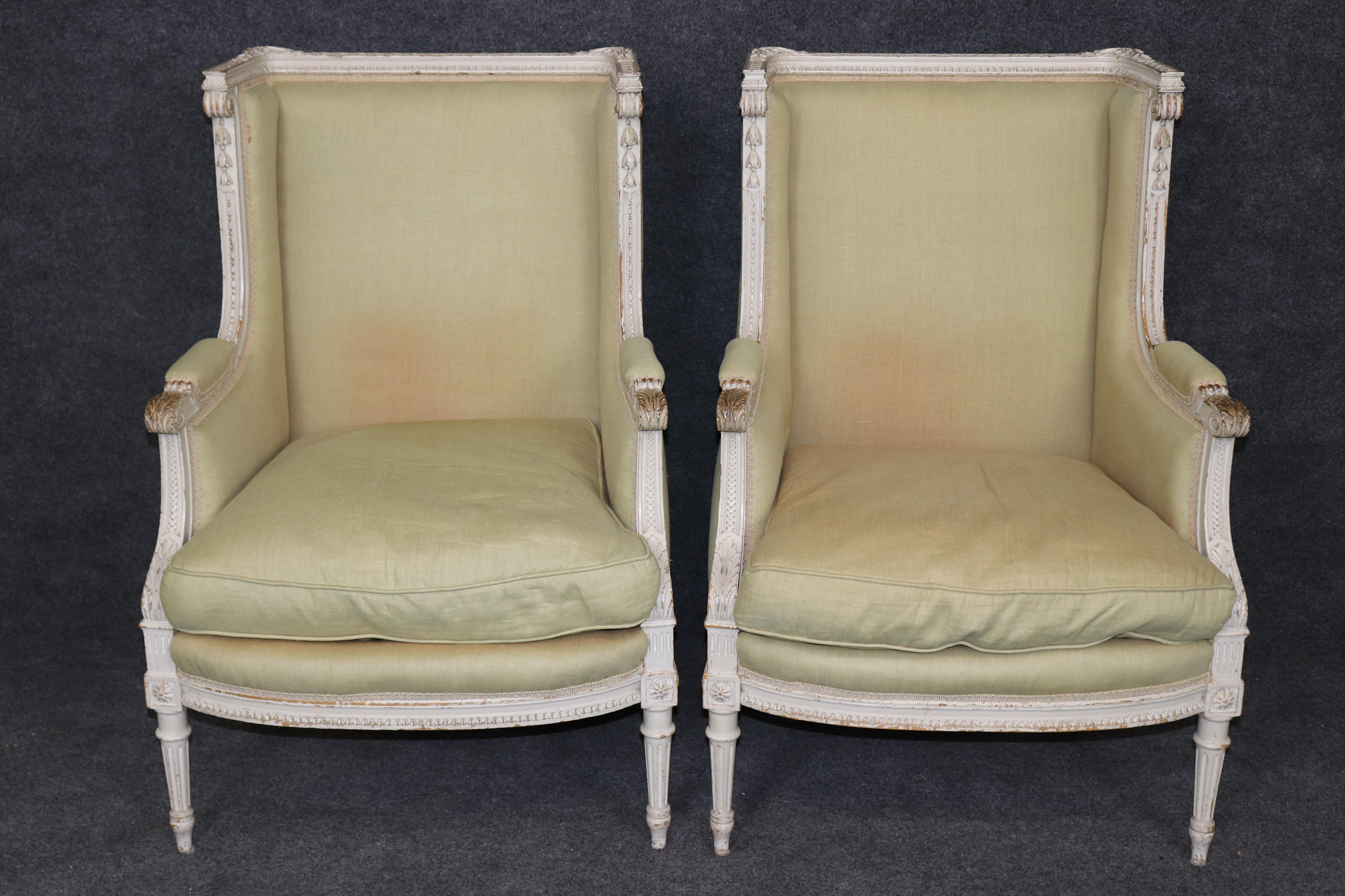 This is a fantastic and rare form of French creme painted bergere chairs. The chairs are gorgeous, with finely carved frames and beautiful distressed antique creme painted lacquer. The frames are in good condition but the upholstery could be redone.