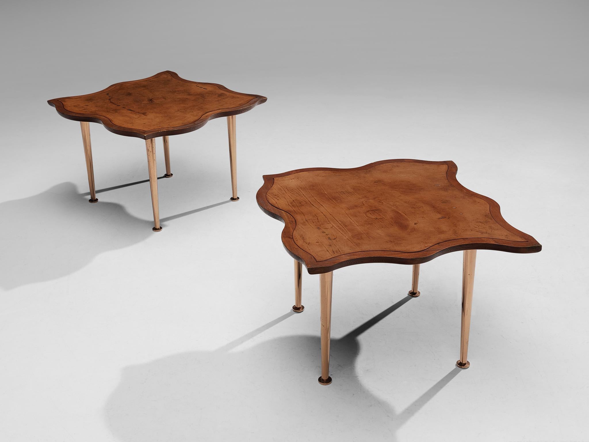 Pair of side tables, pine, leather, copper anodized metal, France, 1960s. 
 
This extraordinary pair of side tables features a remarkable biomorphic tabletop, and due to its shape this set fits together like one puzzle. Beautiful patinated cognac