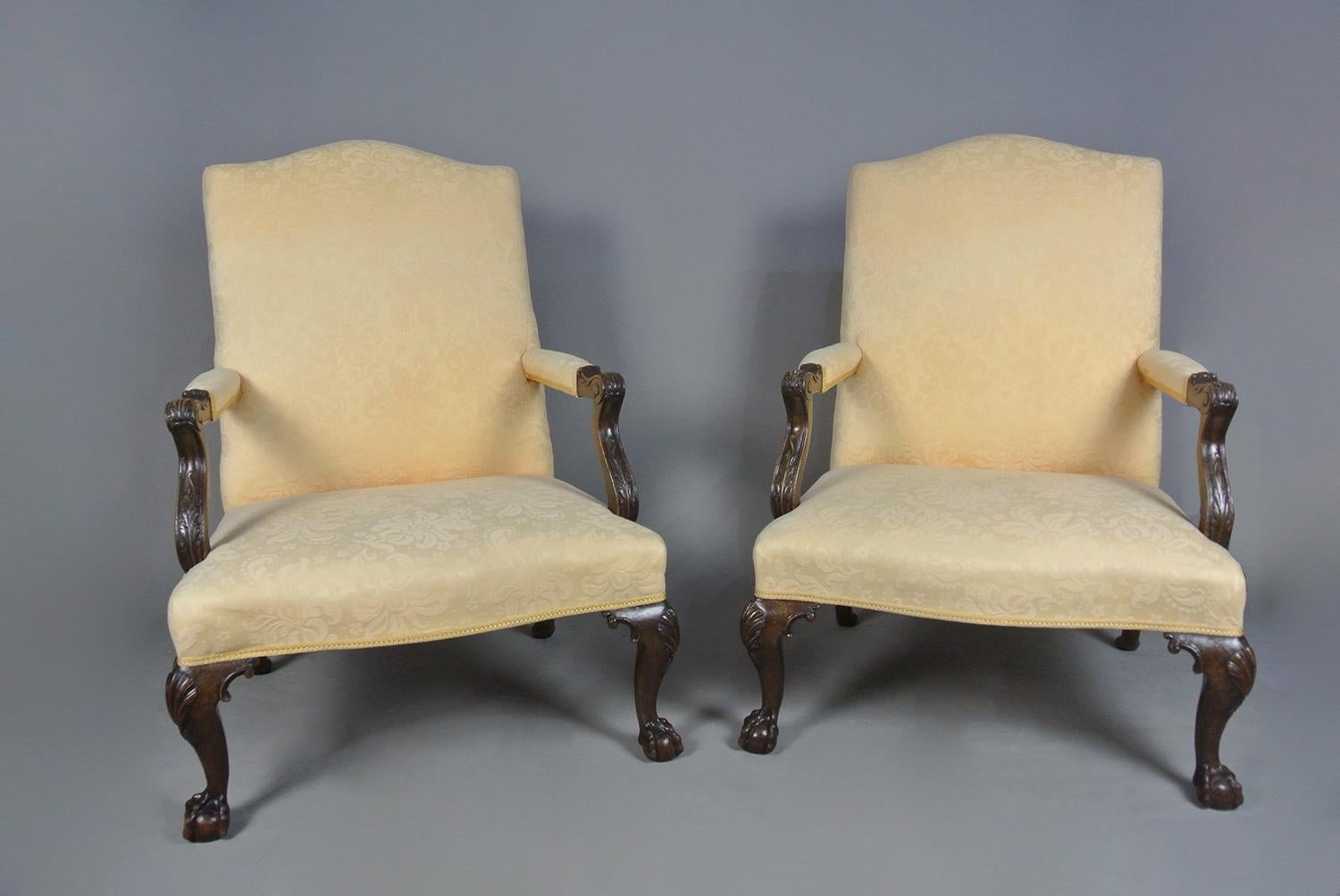 This beautiful pair Gainsborough chairs are hand made in solid walnut with wonderful cabriole legs to front terminating in large well carved claw and ball feet and with lovely scallop shell carvings to the knees.    The rear legs are raked back and