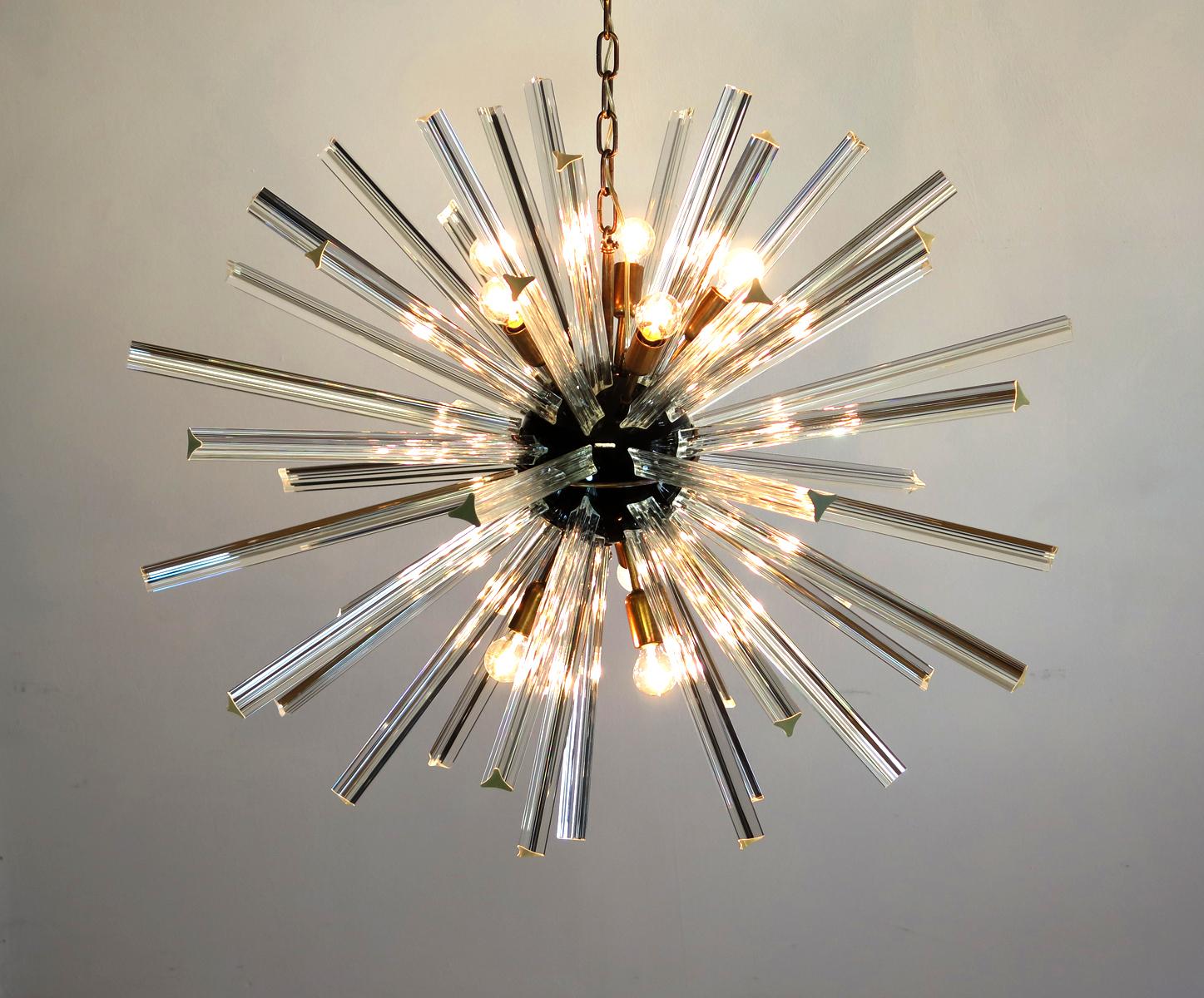 Pair Italian Sputnik chandeliers surrounding 50 crystal glass 'triedri' prisms radiating from a center black metal nucleus. Brass lamp holder.
Period: late 20th century
Dimensions: 51,20 inches (130 cm) height with chain; 27,55 inches (70 cm) height
