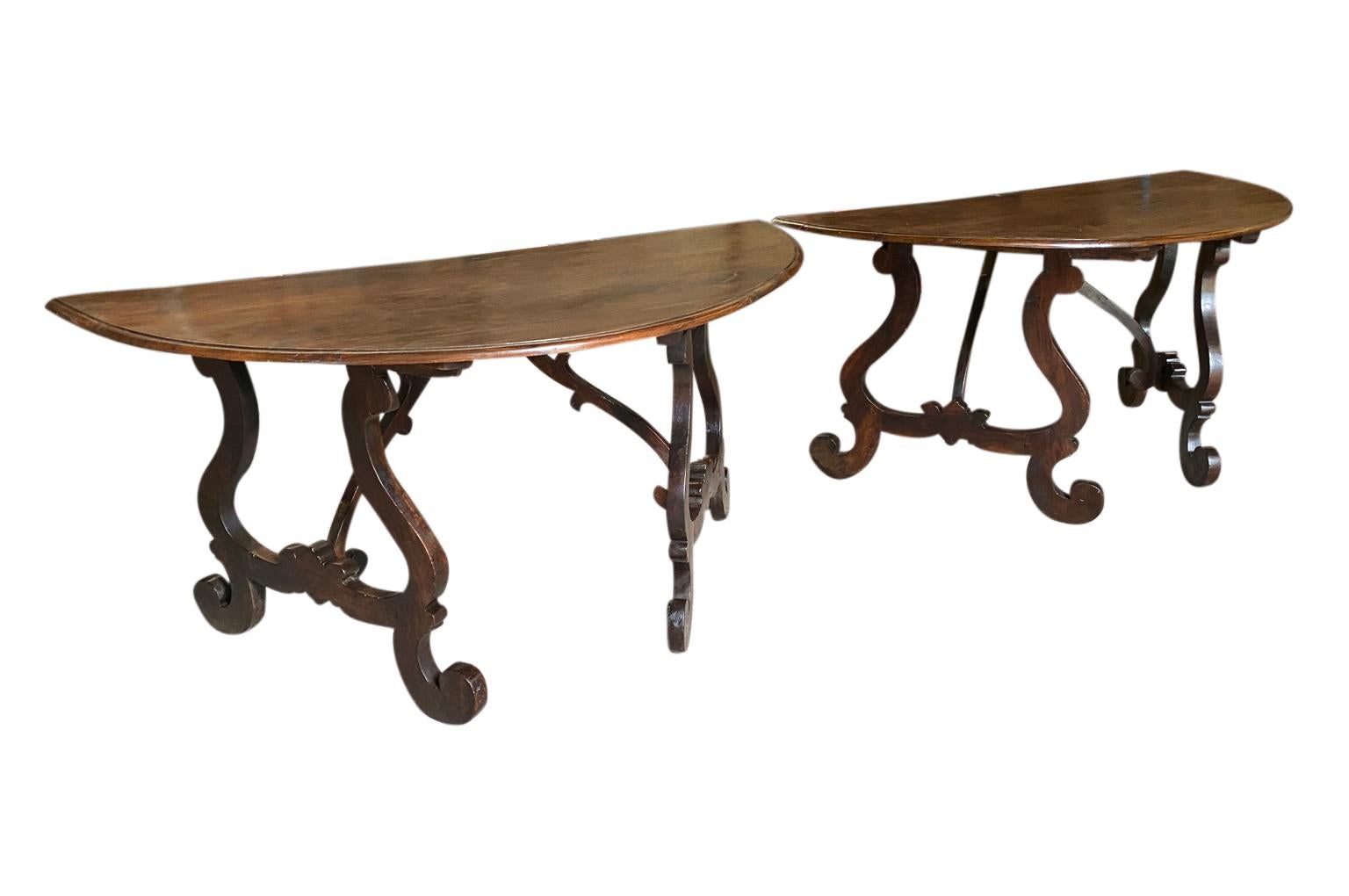 An exceptional and rare pair of Northern Italian grand scale Demi Lune console tables expertly crafted from stunning walnut with classical lyre shaped legs. Excellent patina.