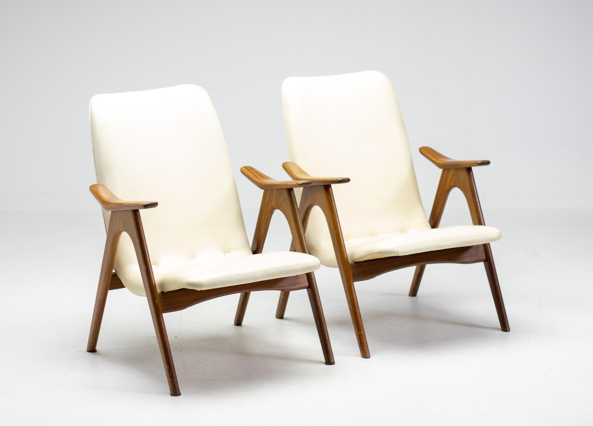 Ensemble original de 2 chaises longues conçues par le designer néerlandais Louis Van Teeffelen.
Le cadre en noyer et le revêtement en Naugahyde blanc cassé sont tous deux en parfait état d'origine.

Louis van Teeffelen (1921-1972) était un designer